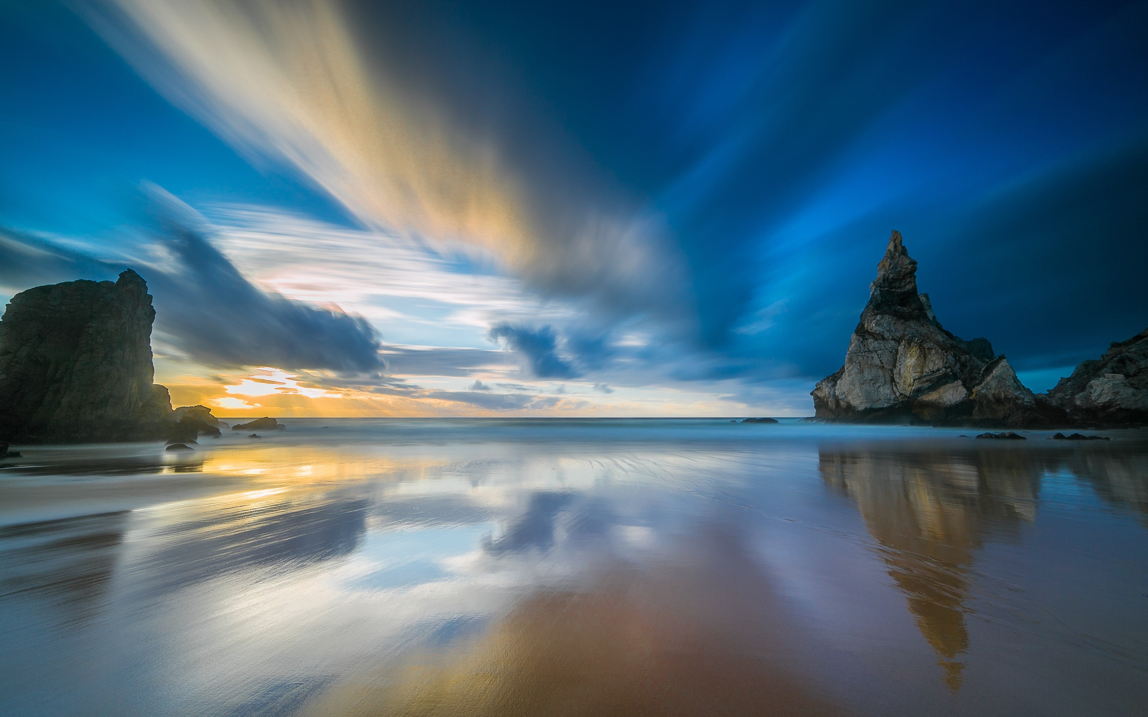 Ocean with rock formations and streaking clouds HD Wallpaper