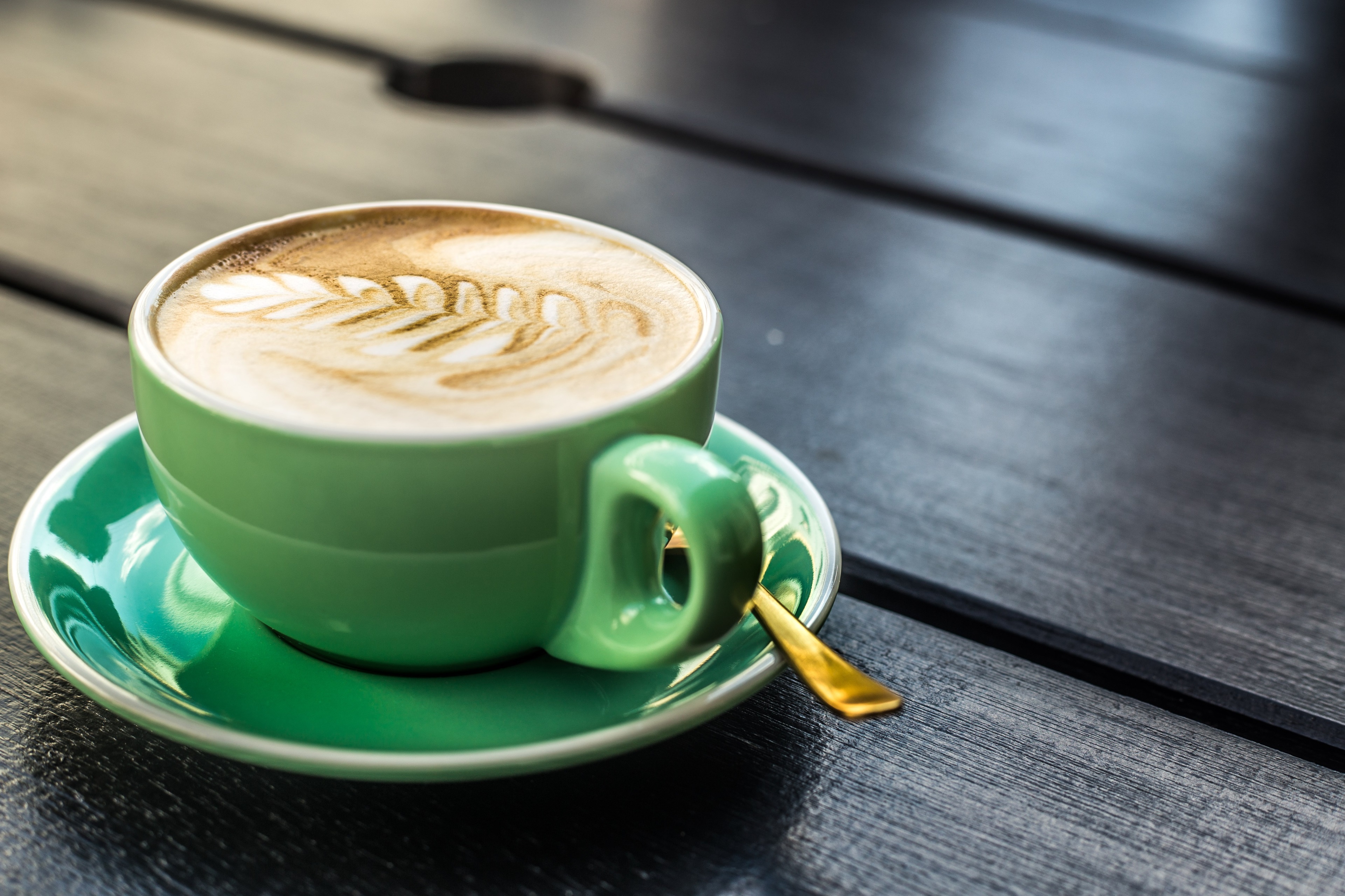 Latte art coffee in a green cup on a saucer HD Wallpaper