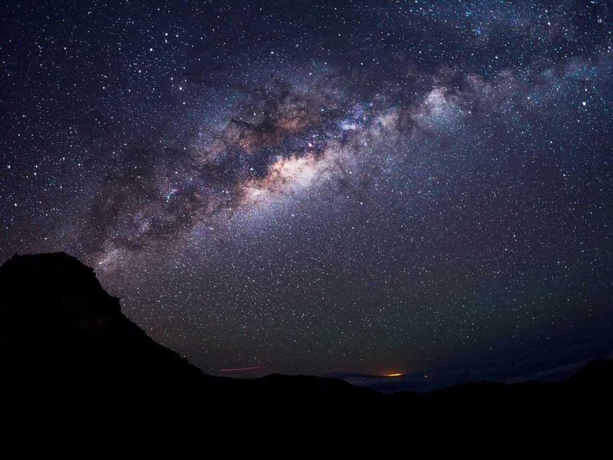 Milky Way galaxy over a silhouetted mountain range HD Wallpaper
