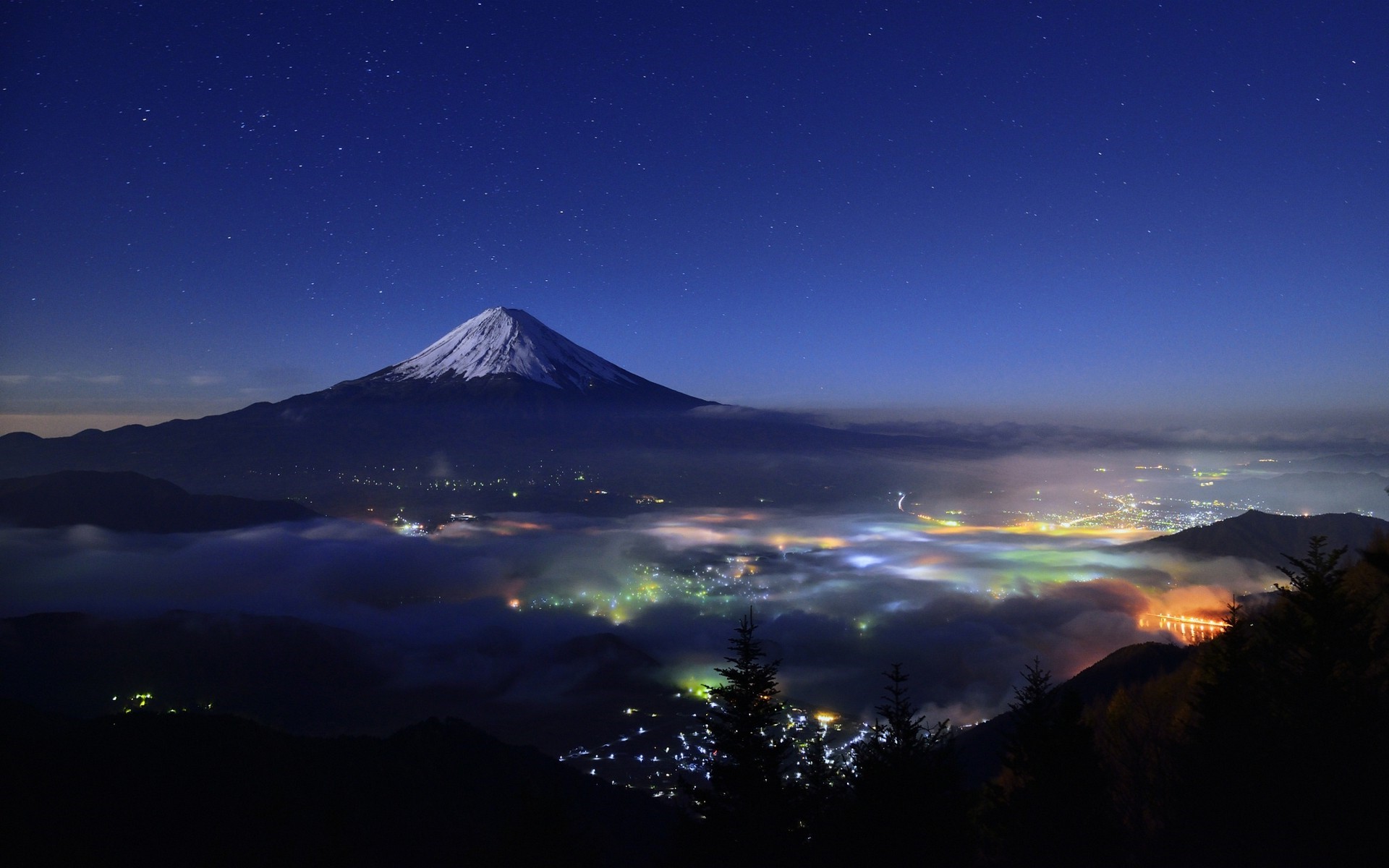 Mount Fuji at night with city lights and stars HD Wallpaper