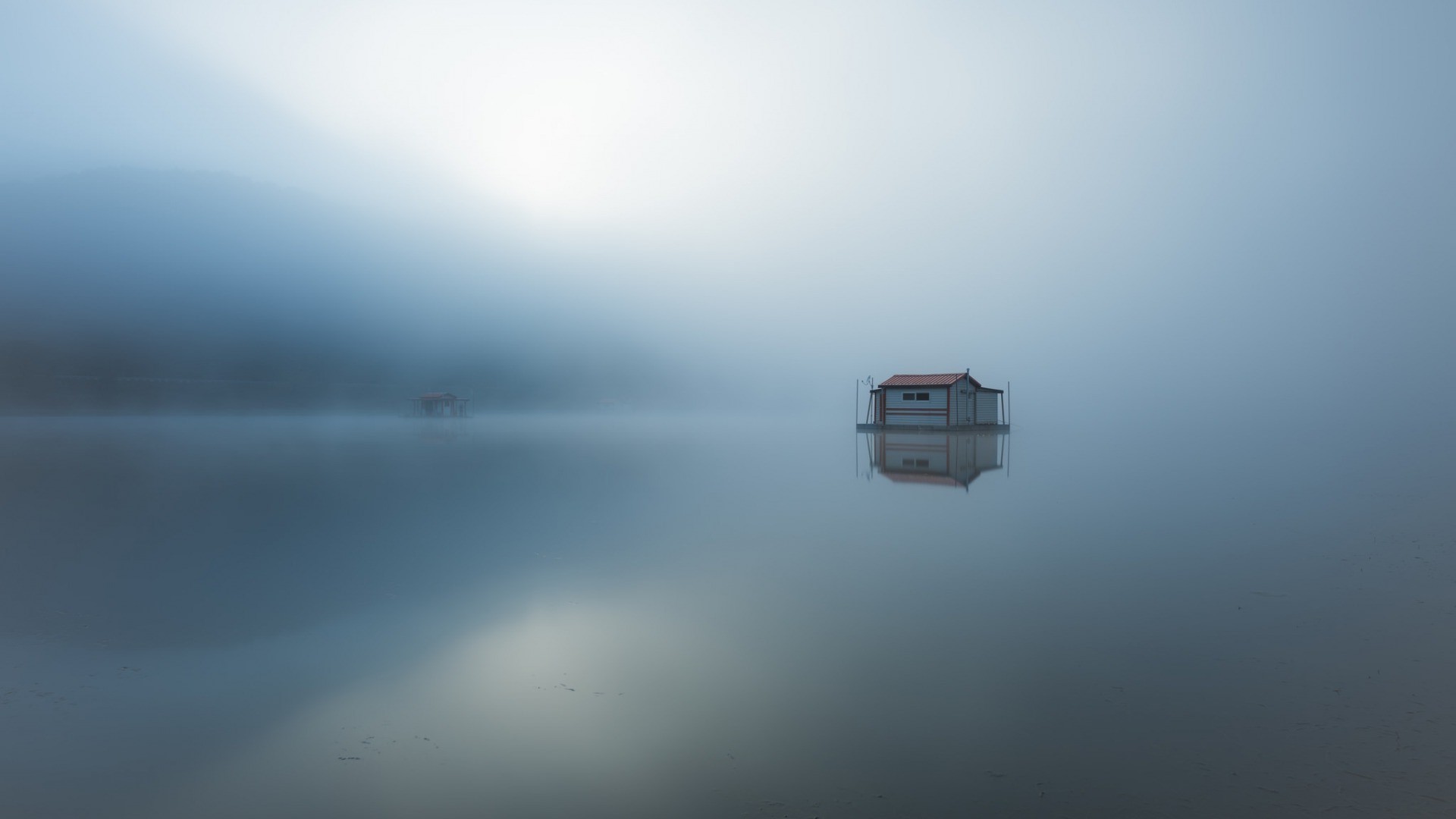 Floating house on a misty lake with reflections HD Wallpaper