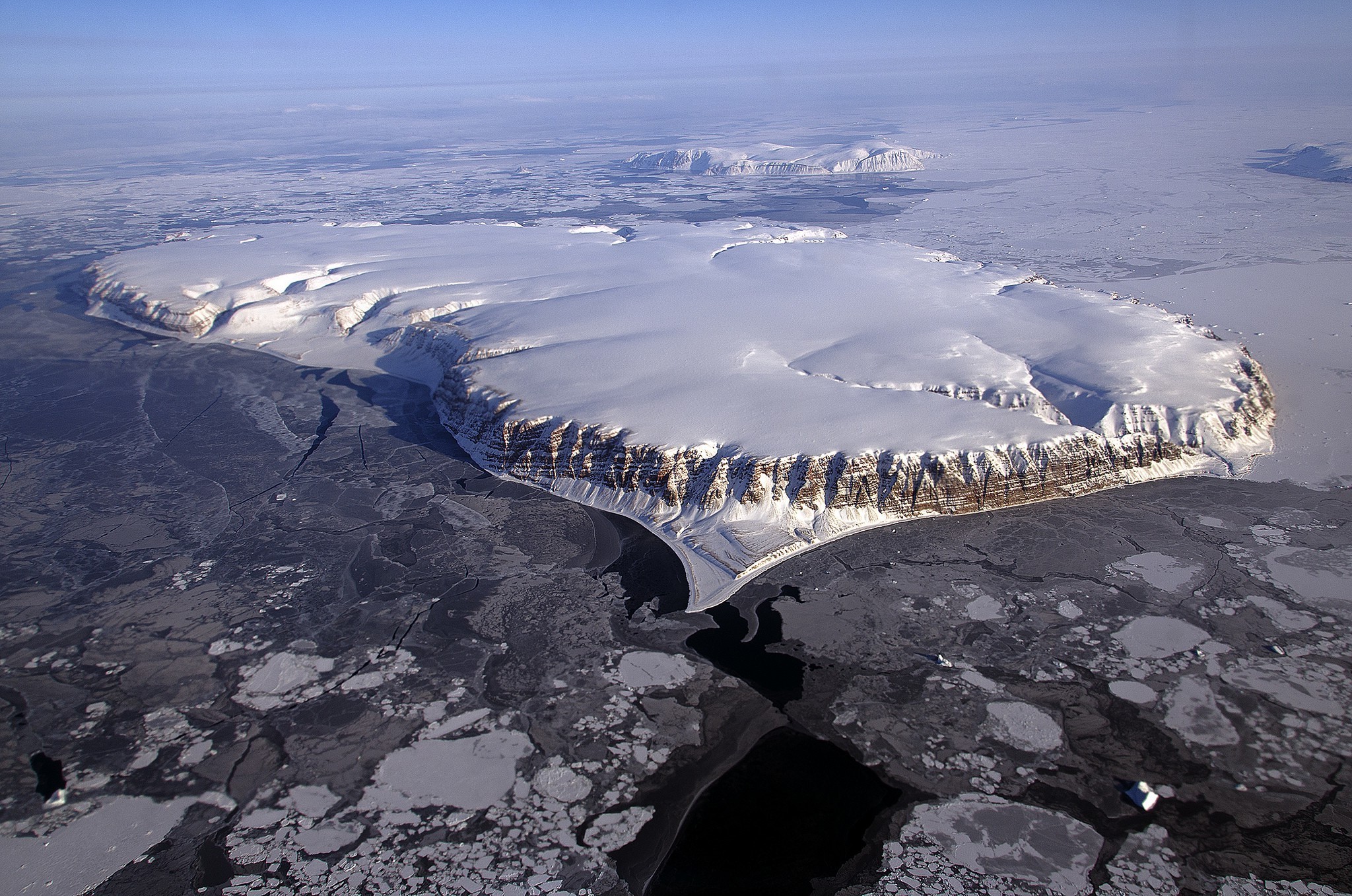 Aerial view of a snow-covered island with glaciers and ice floes HD Wallpaper