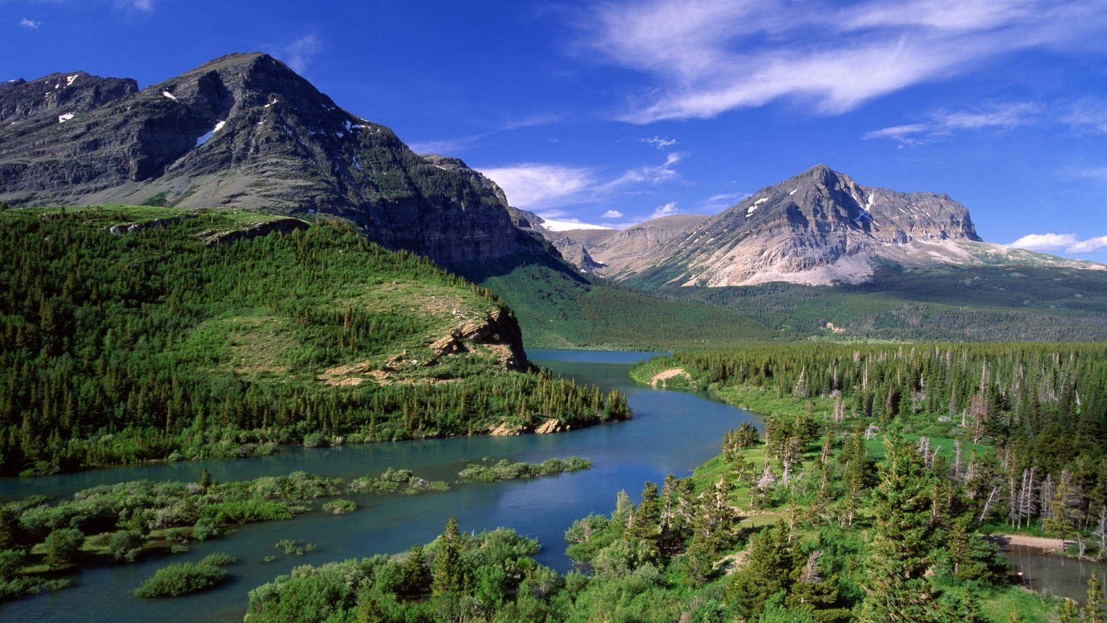 River flowing through a forest with mountains under a blue sky HD Wallpaper