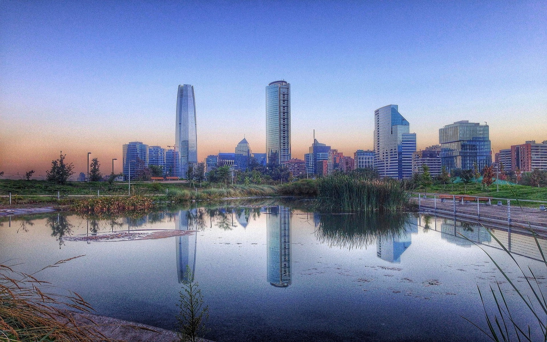 Santiago de Chile cityscape with skyscrapers and pond at sunrise HD Wallpaper