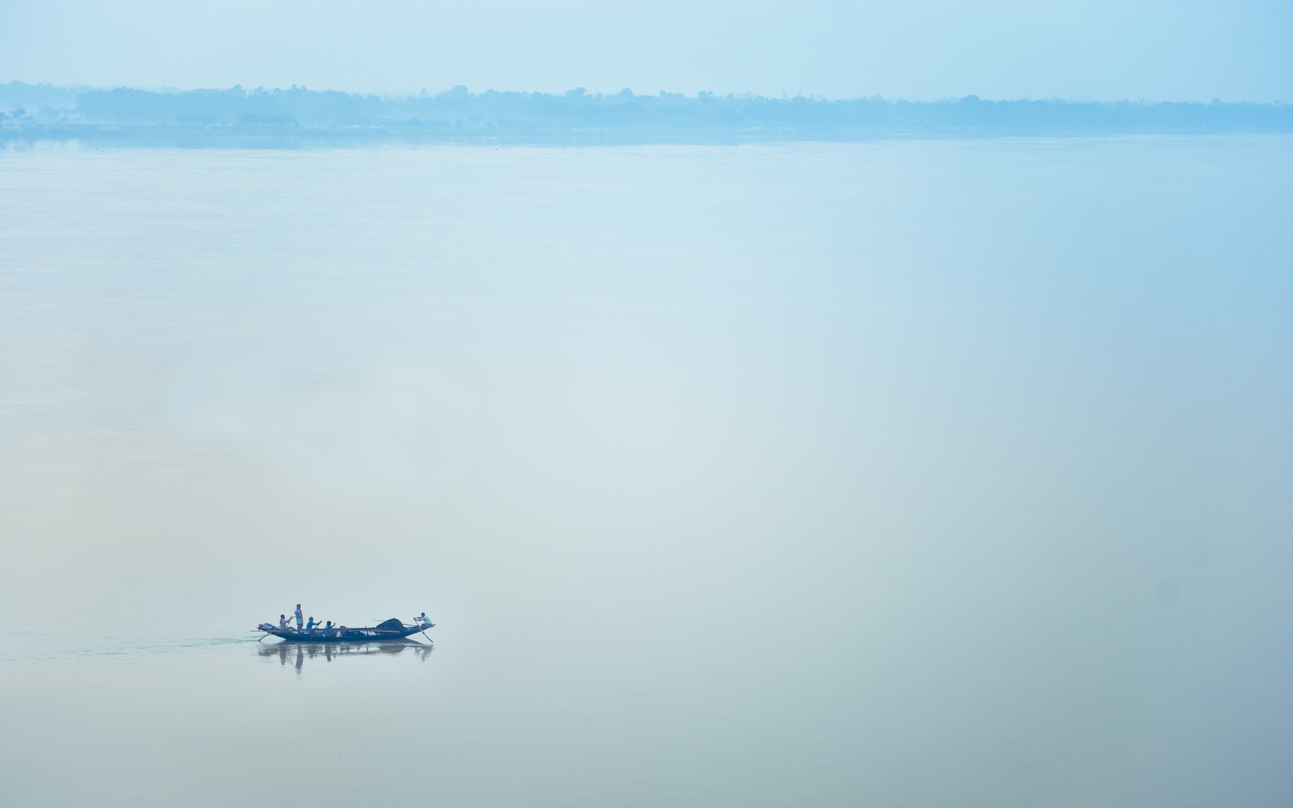 Boat with people on a calm river with distant trees HD Wallpaper
