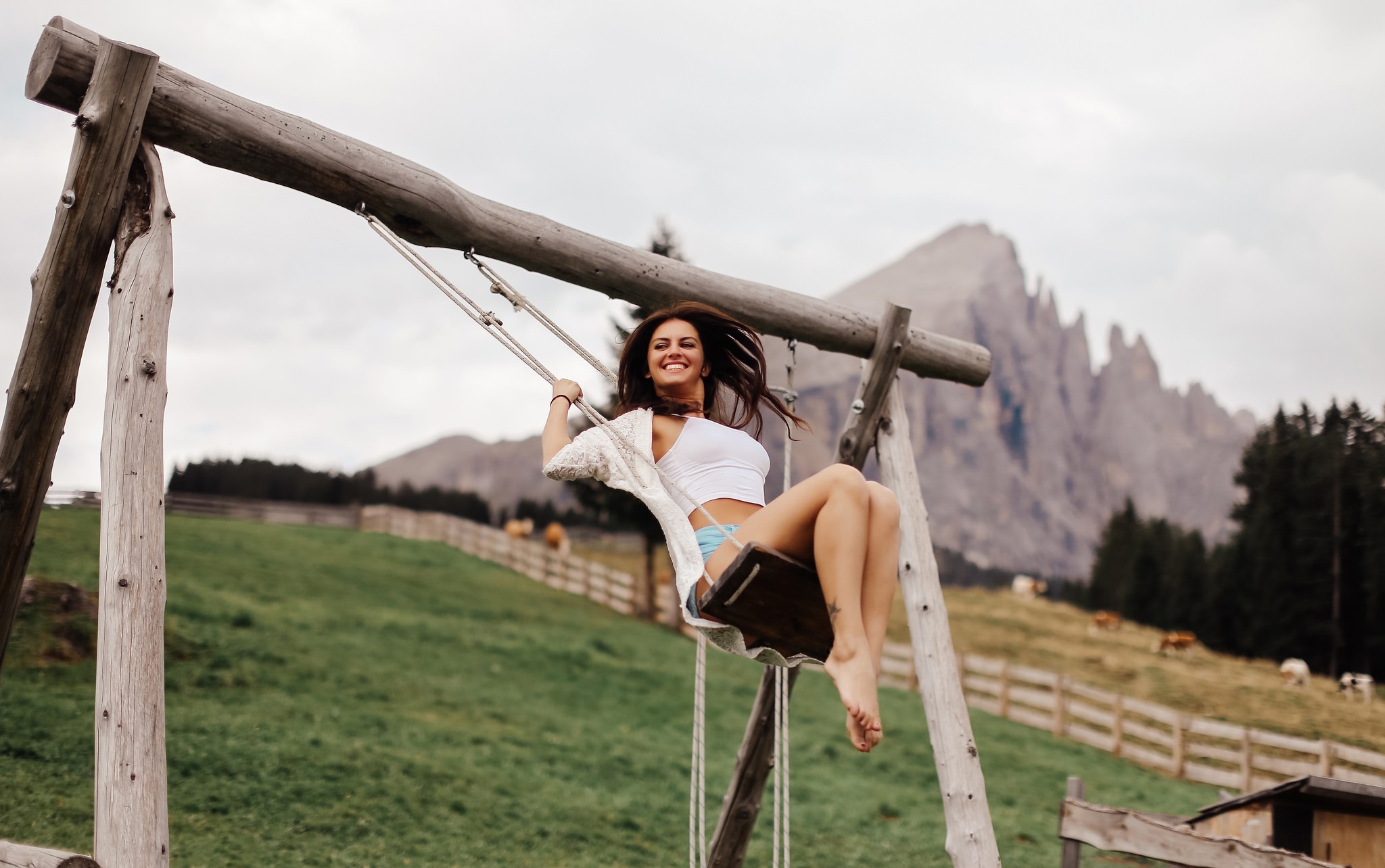 Woman on a swing in the mountains HD Wallpaper