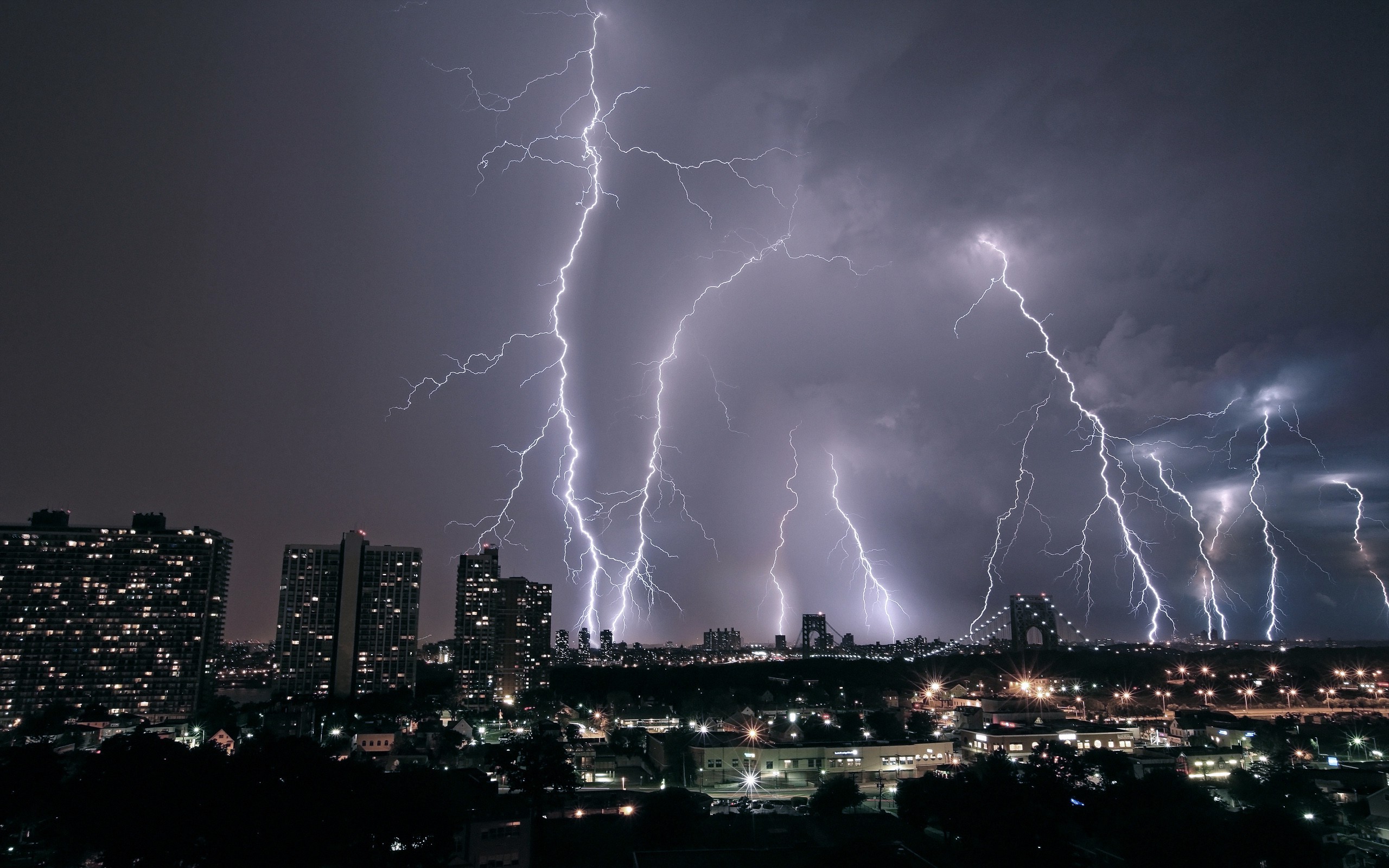 Lightning strikes over a city at night HD Wallpaper