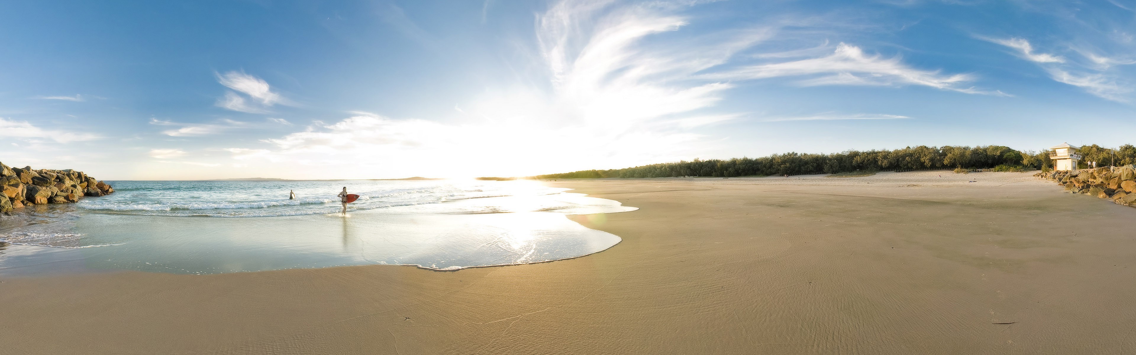 Panorama of a beach with surfers and ocean HD Wallpaper