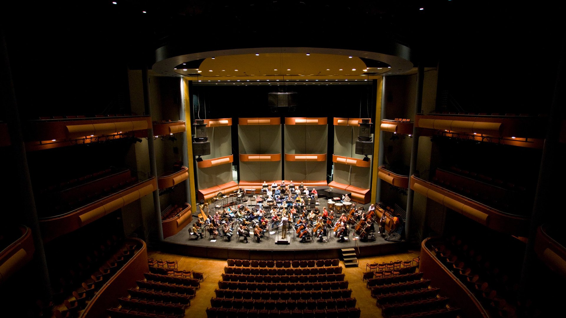 Orchestra rehearsing on a theater stage HD Wallpaper