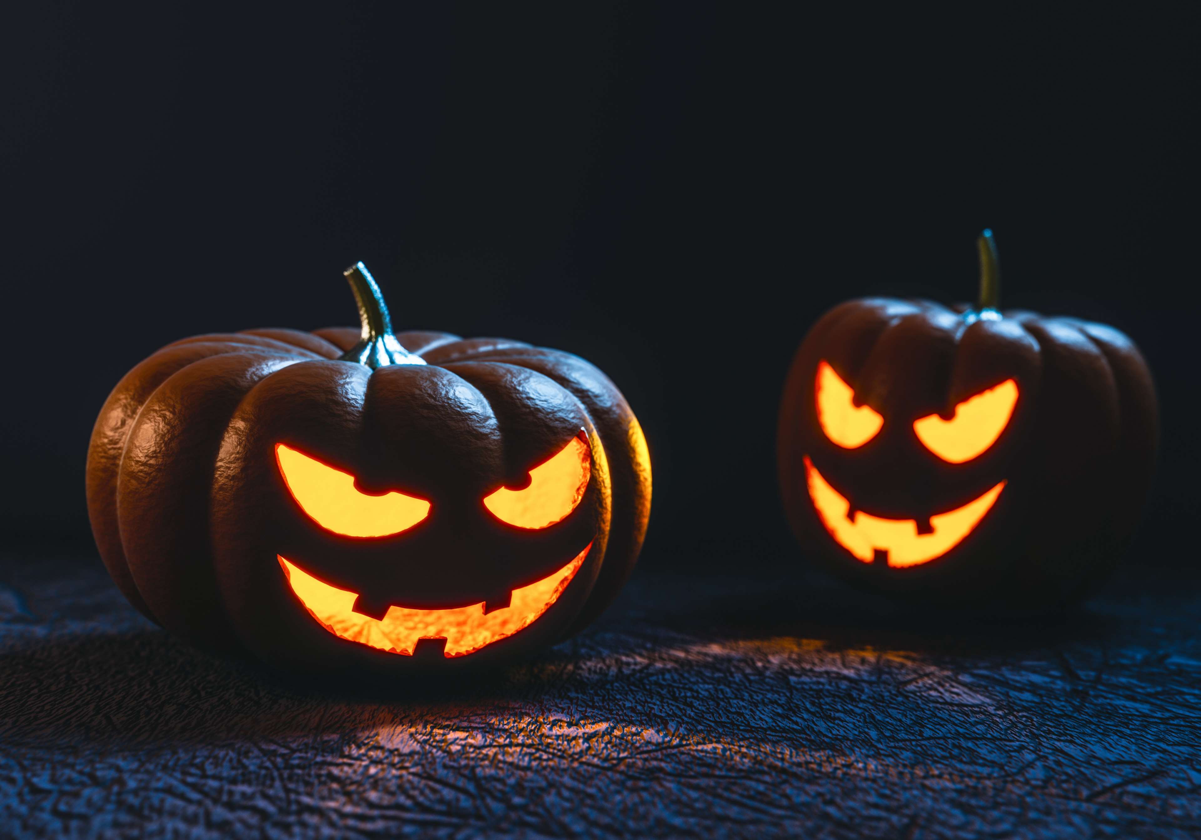 Two carved Halloween pumpkins with glowing faces HD Wallpaper