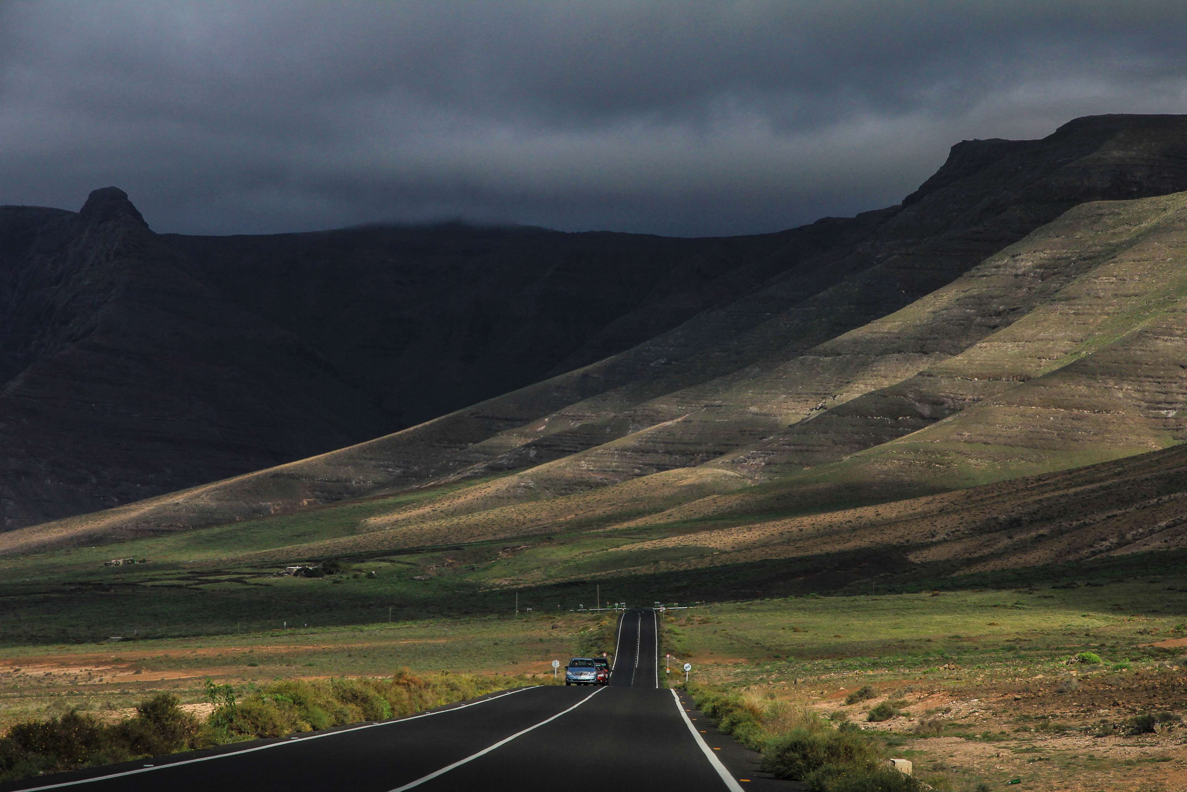 Road through mountains under cloudy sky 4K HD Wallpaper