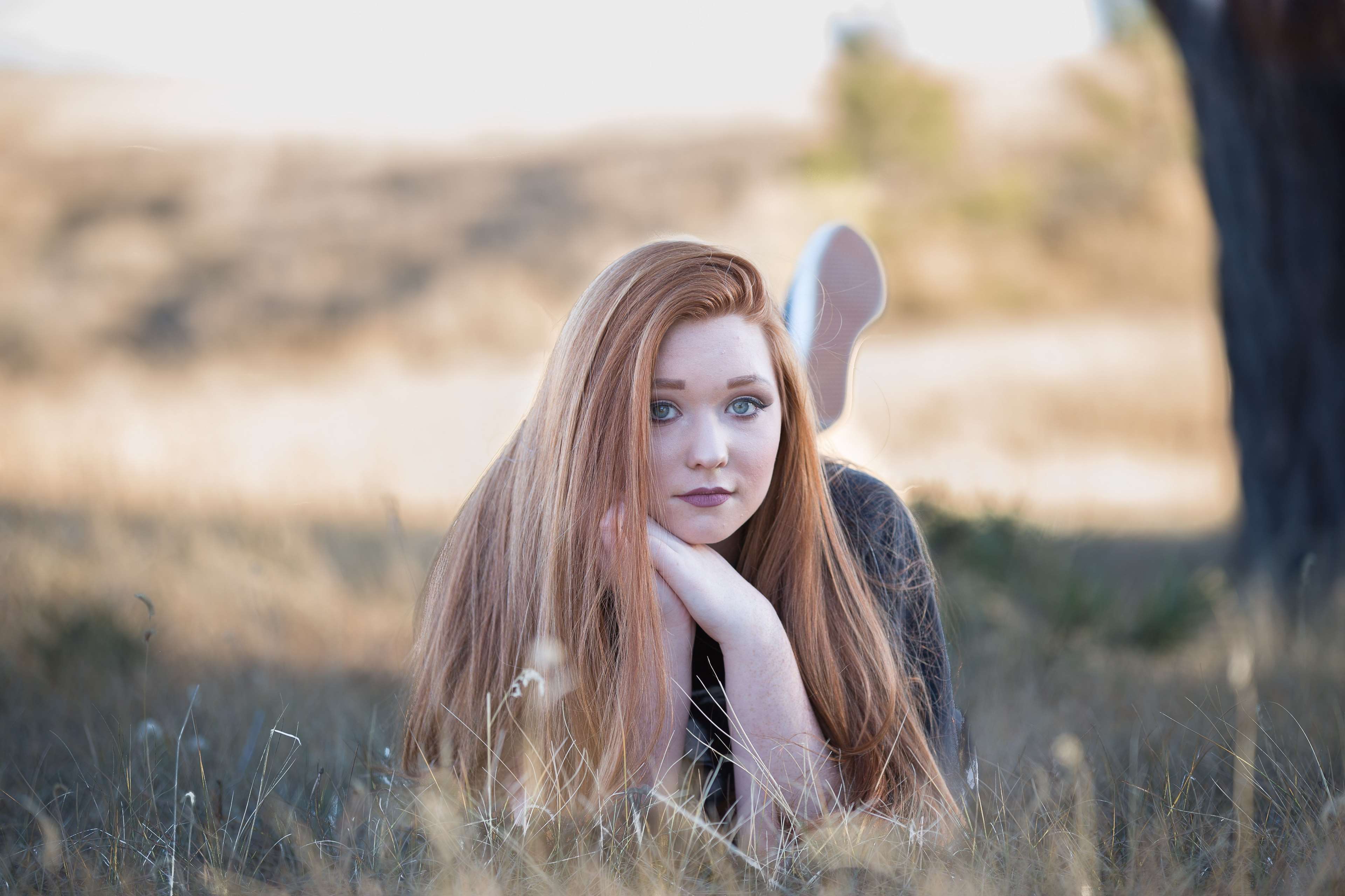 Young redhead woman lying in a field HD Wallpaper