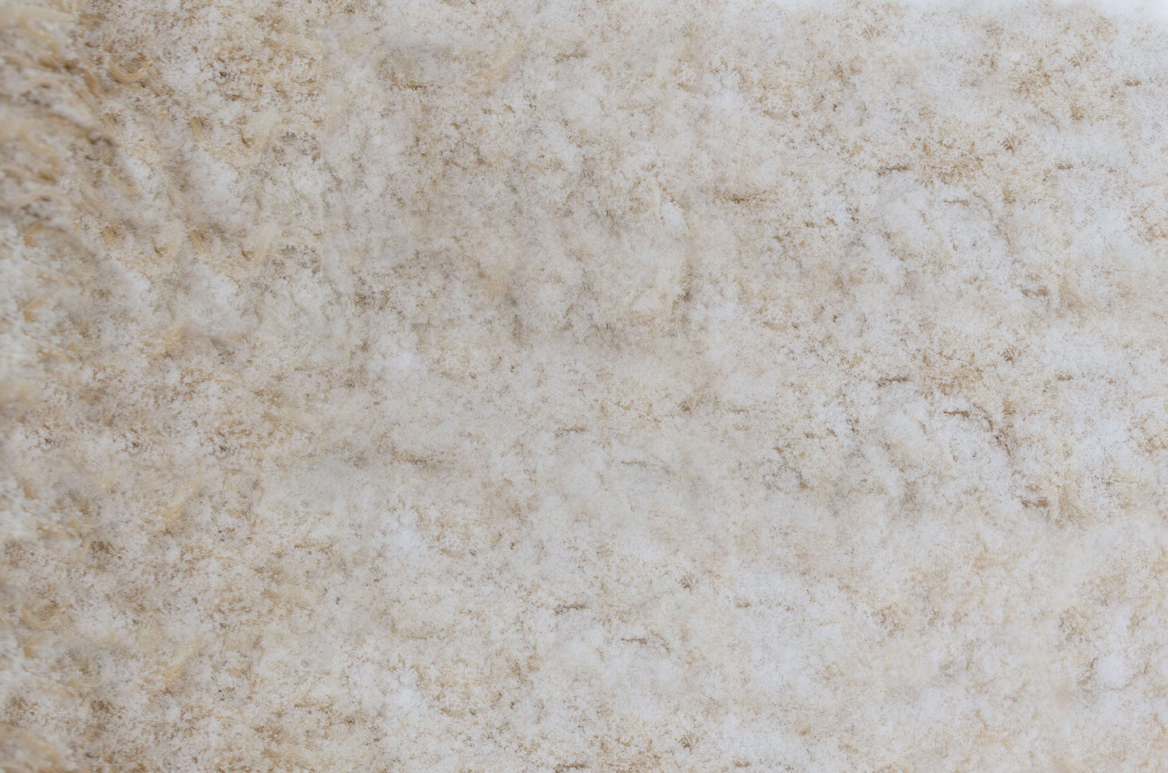 Close-up of a beige and brown mottled natural material HD Wallpaper