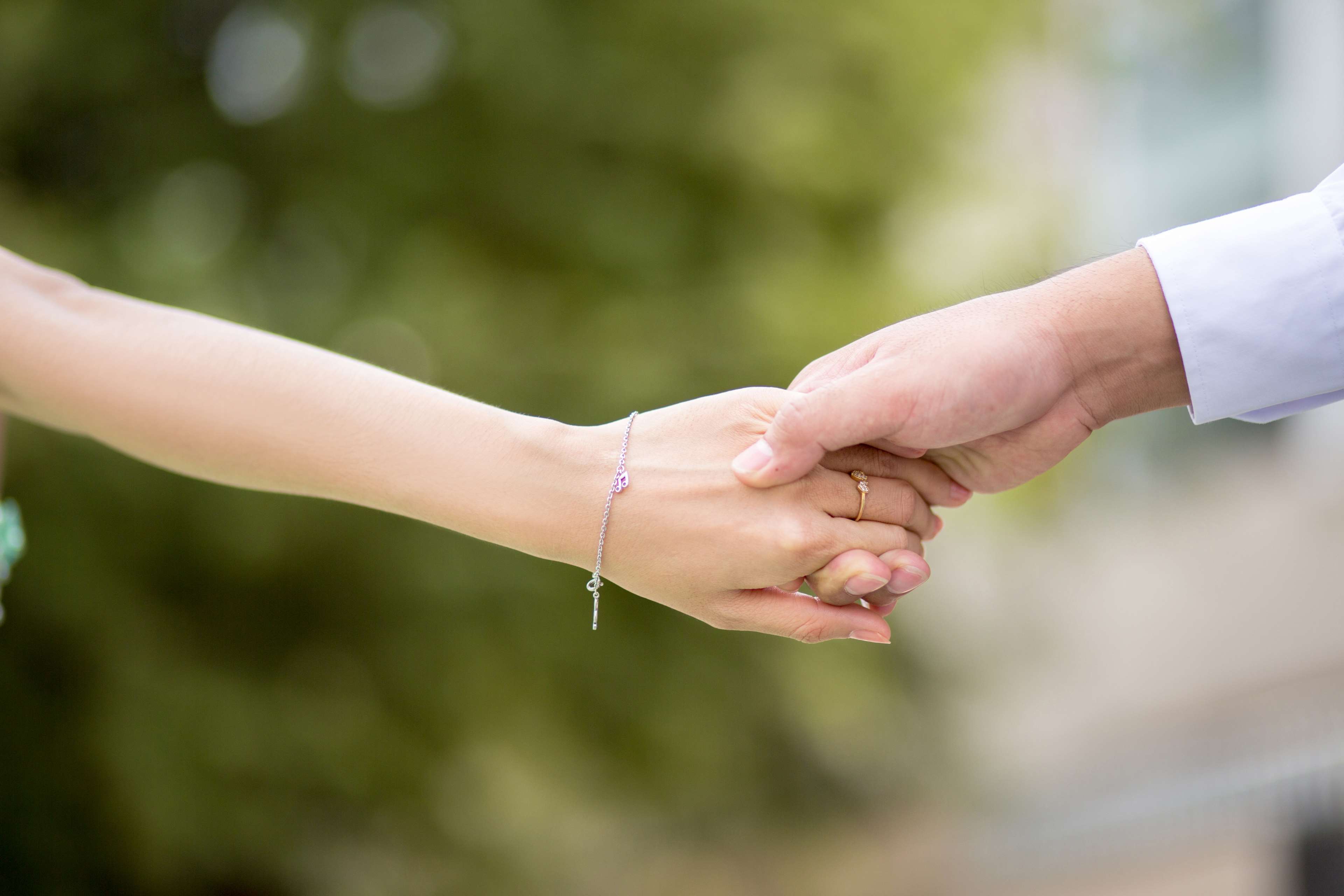 Couple holding hands with wedding ring and bracelet HD Wallpaper