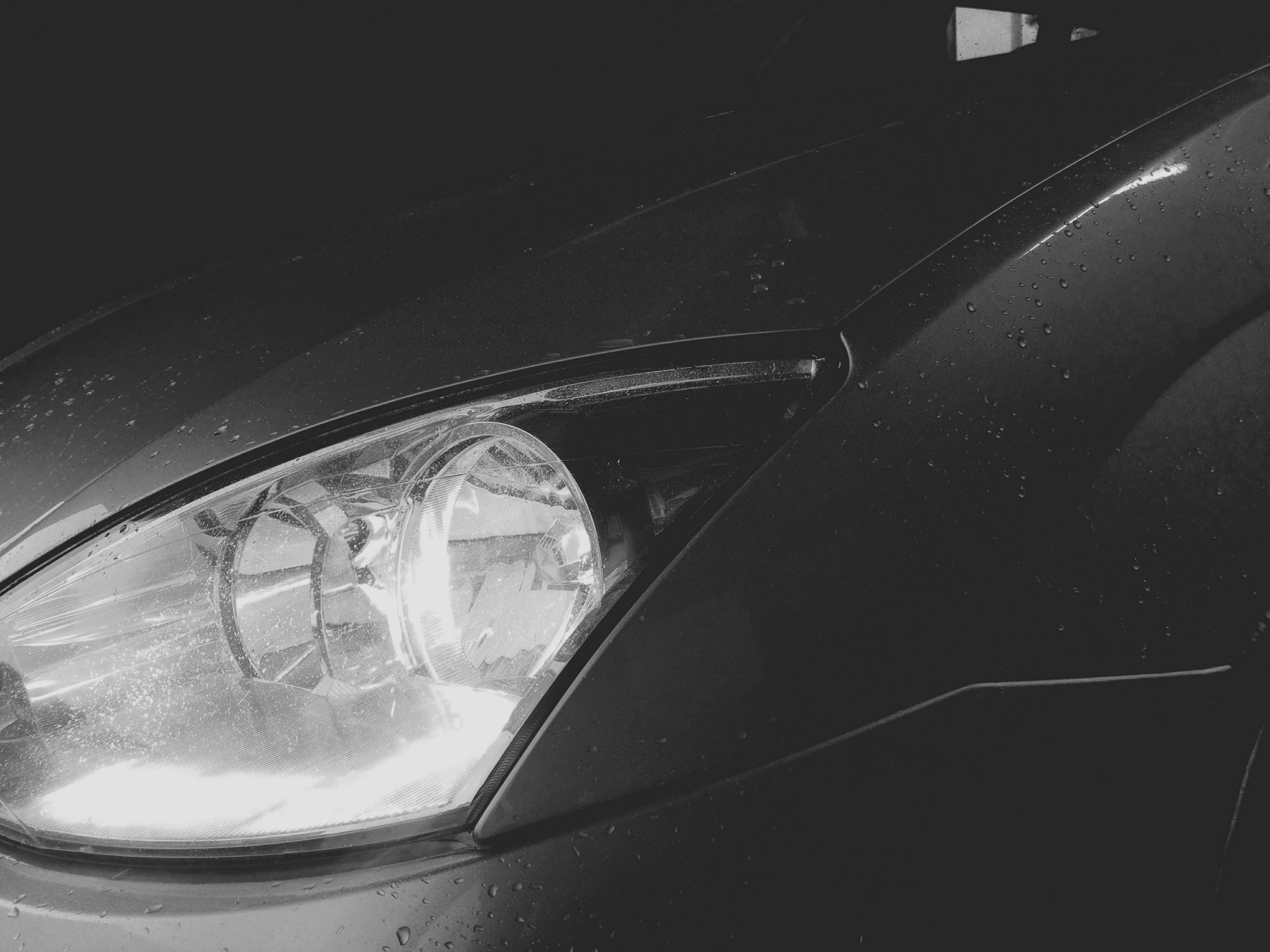 Wet Ford car headlight in black and white HD Wallpaper