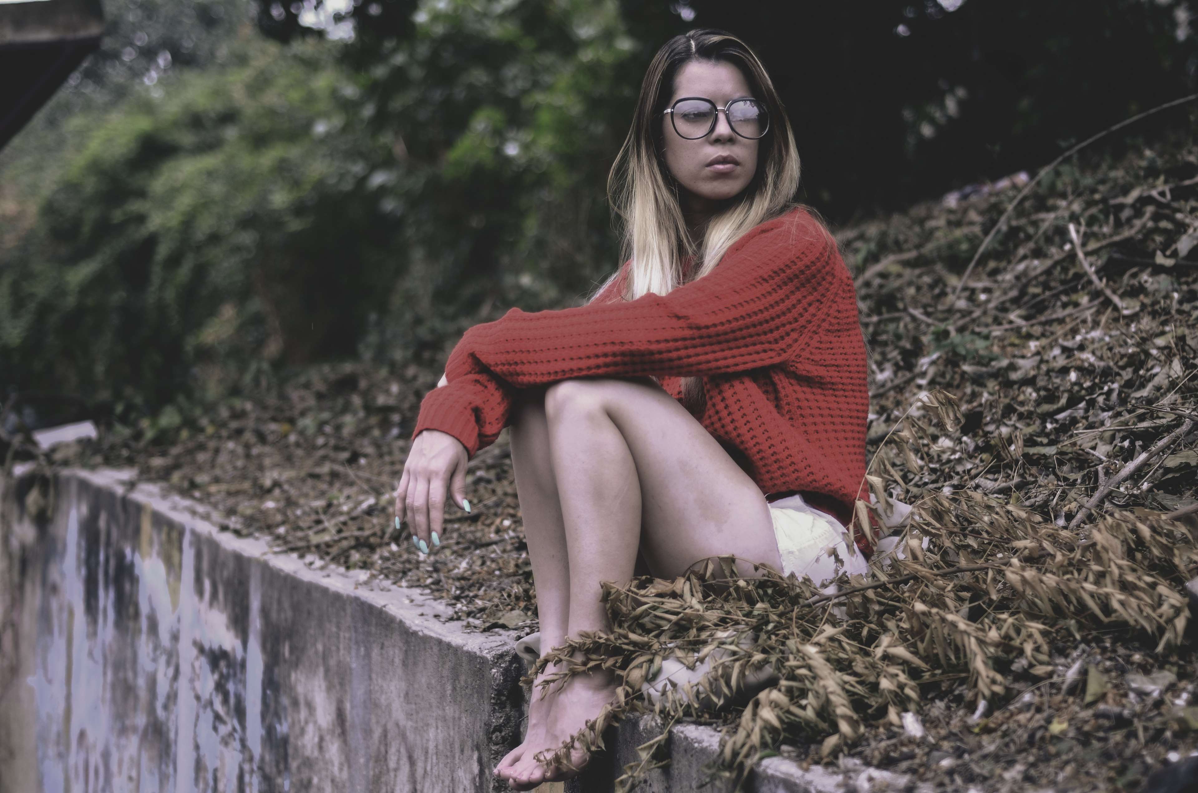 Woman in red sweater sitting on a wall HD Wallpaper