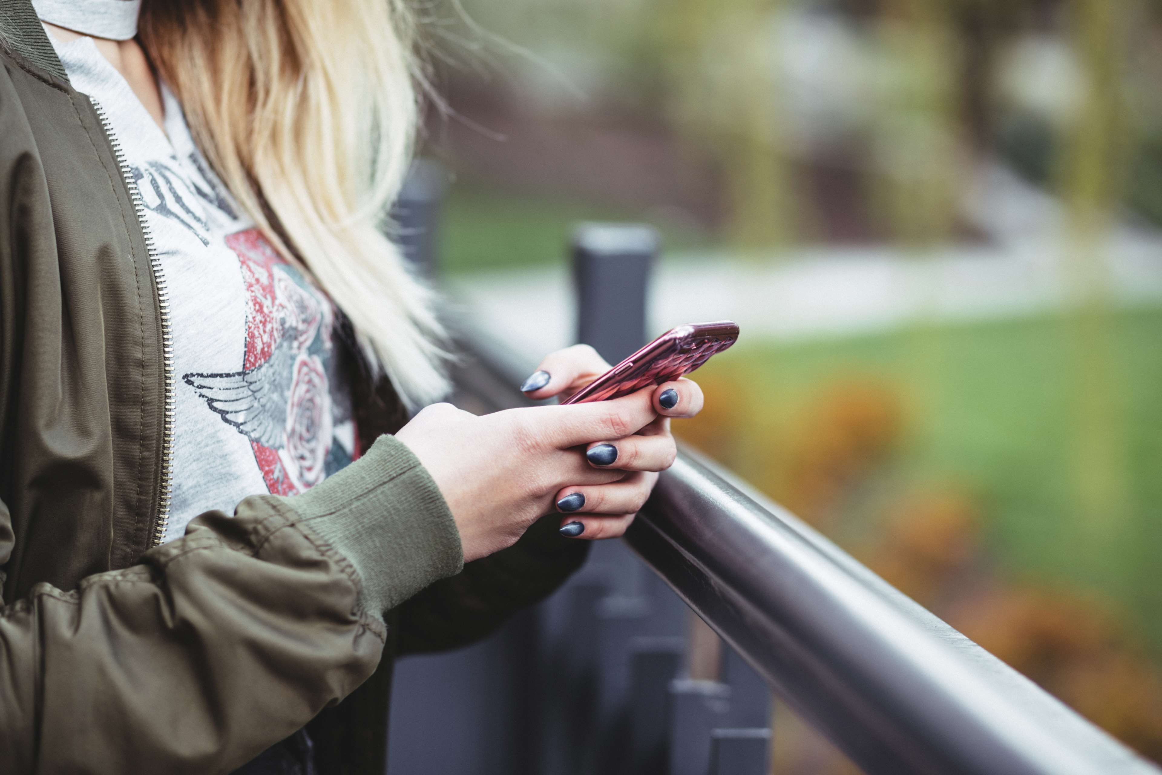 Woman with blonde hair holding a smartphone HD Wallpaper