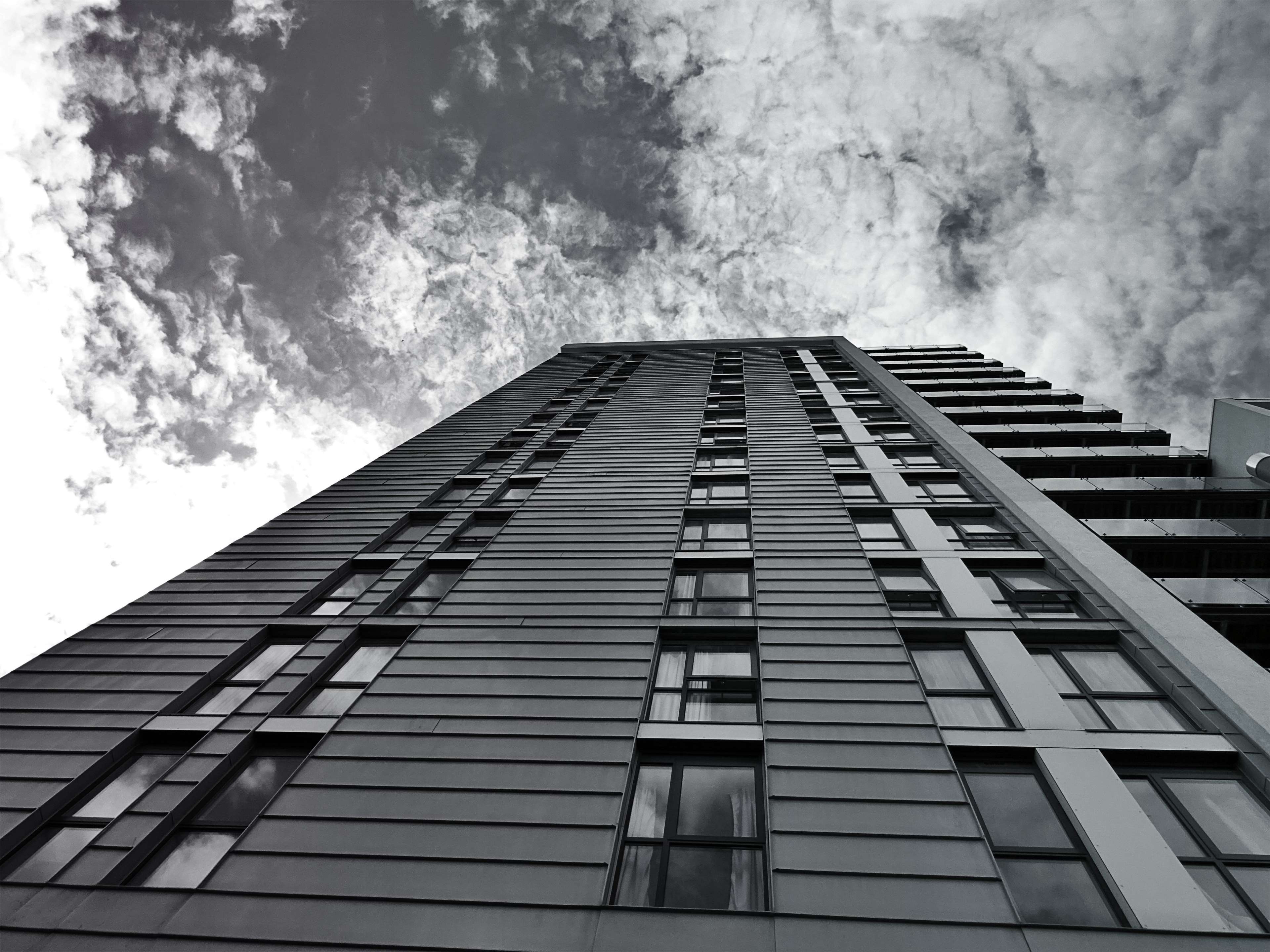 Modern building with glass windows against cloudy sky HD Wallpaper