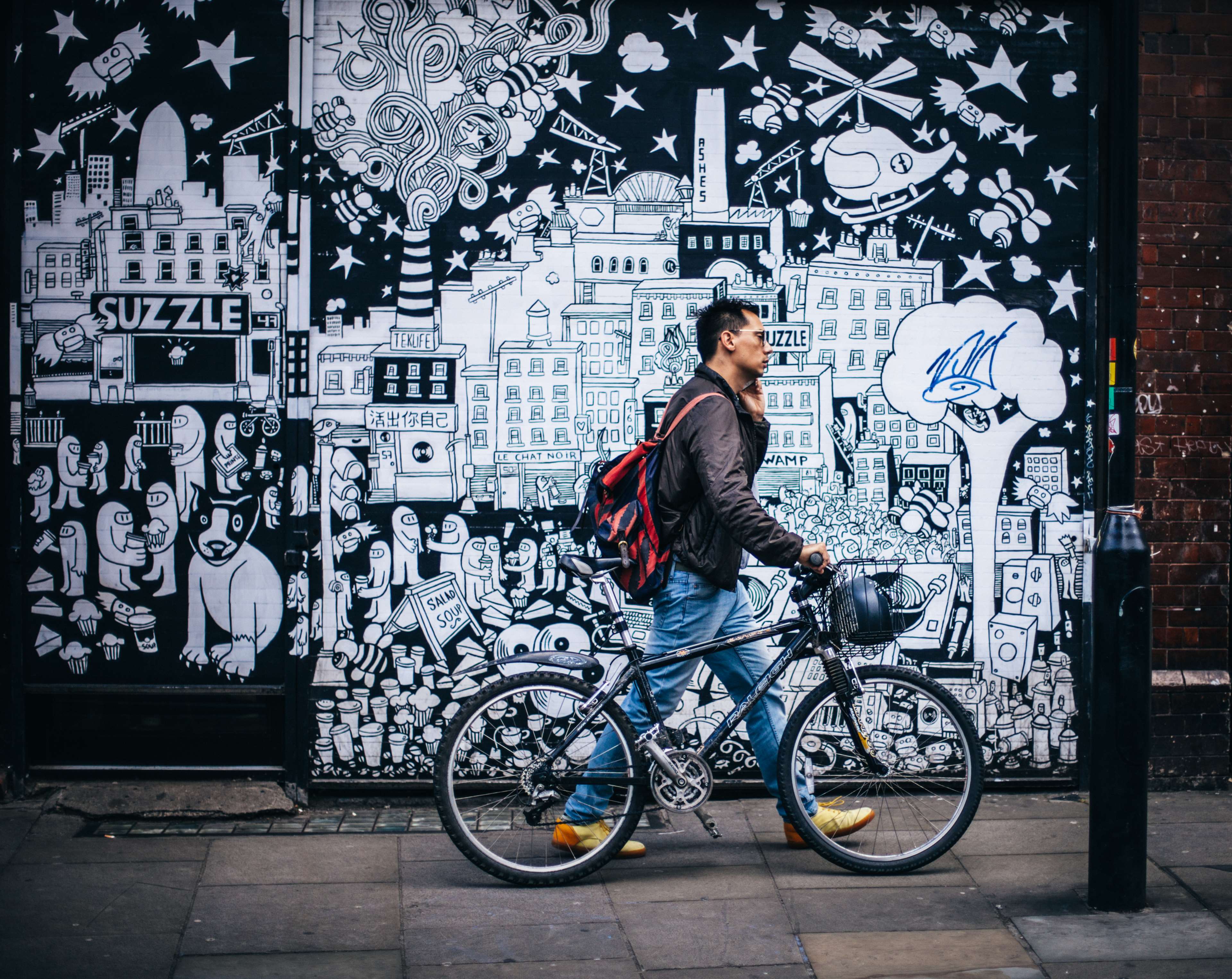 Man with bicycle in front of graffiti mural HD Wallpaper
