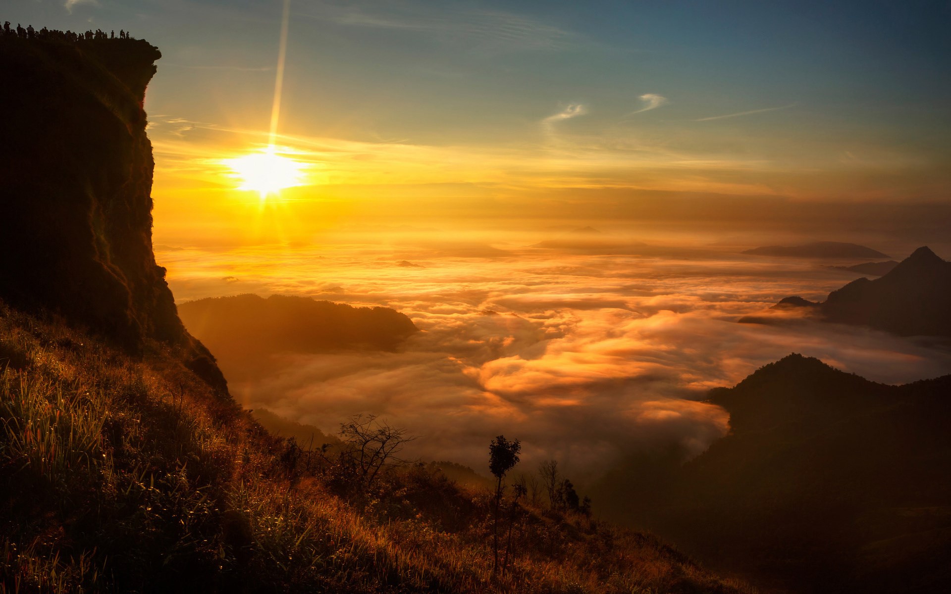 Sunrise over a sea of clouds from a mountain cliff HD Wallpaper
