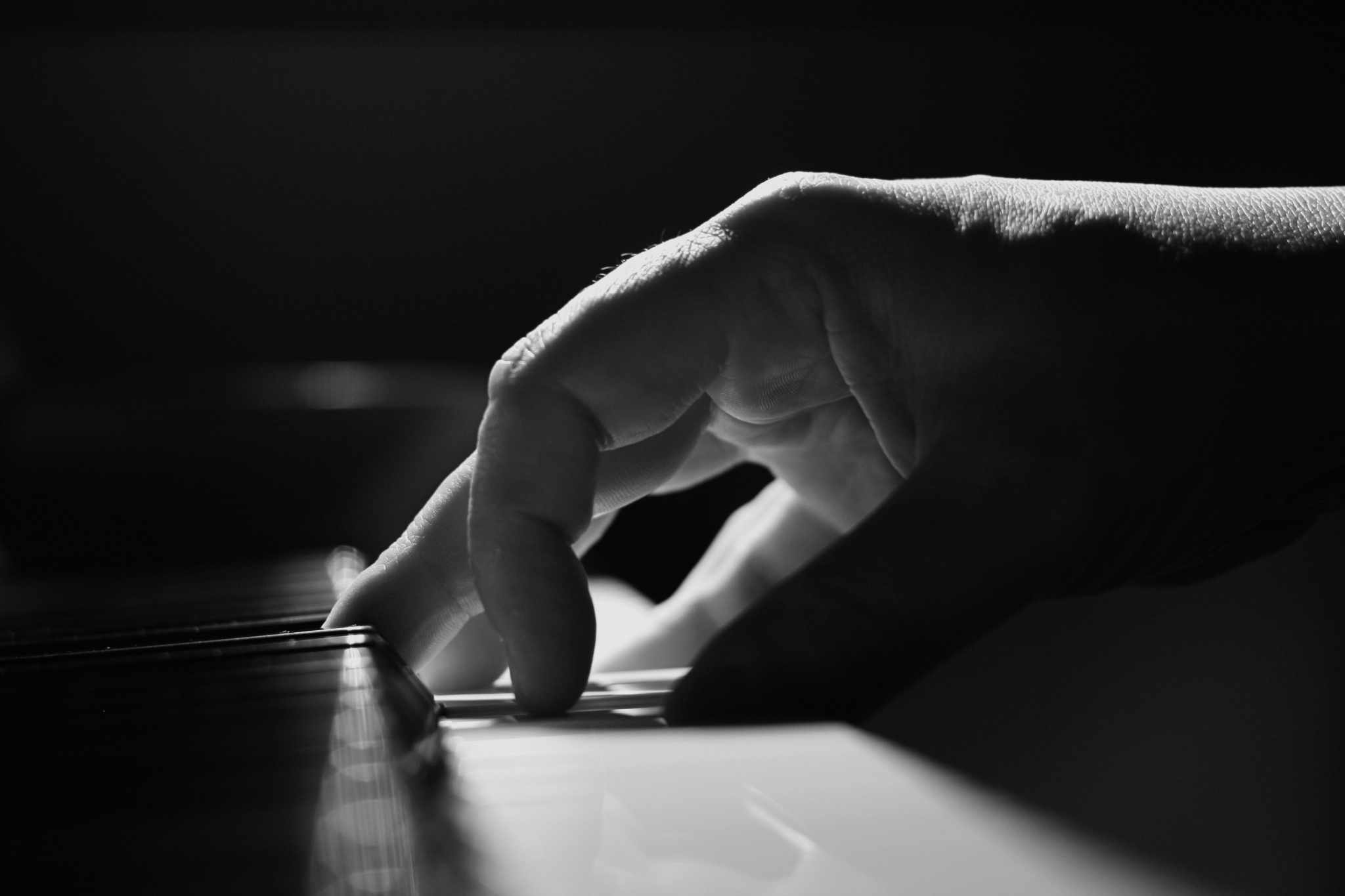 Close-up of a hand playing a piano HD Wallpaper