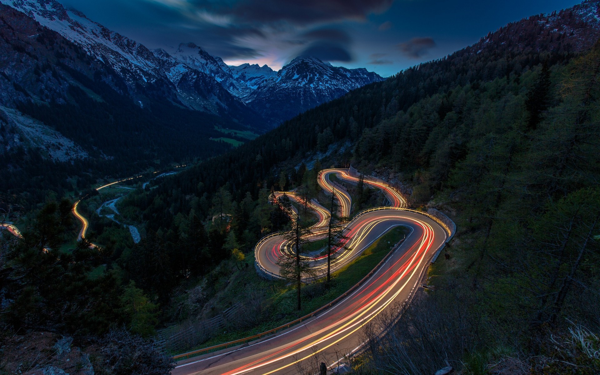 Mountain road with car light trails at dusk HD Wallpaper