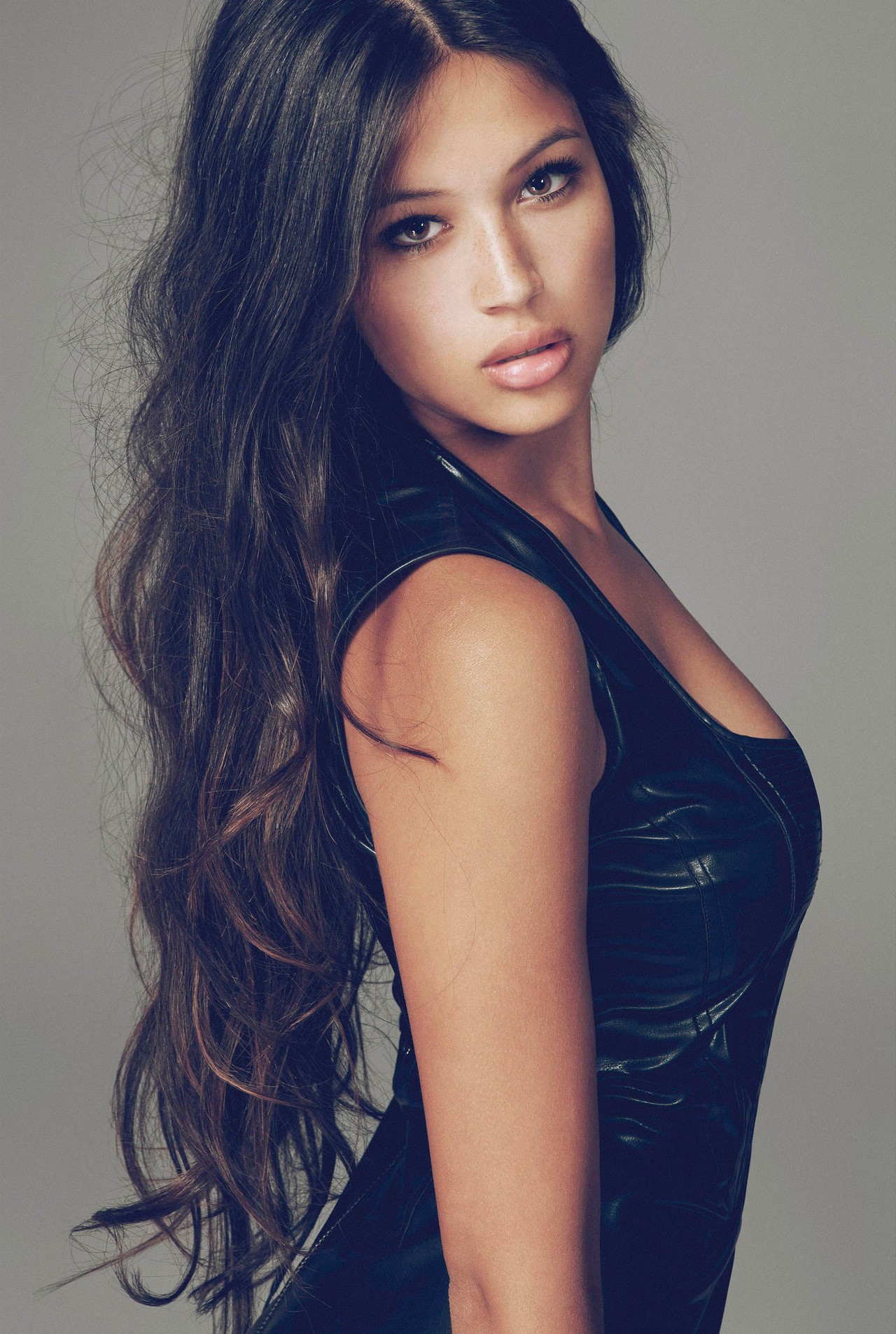 Woman with long dark wavy hair in a black top HD Wallpaper