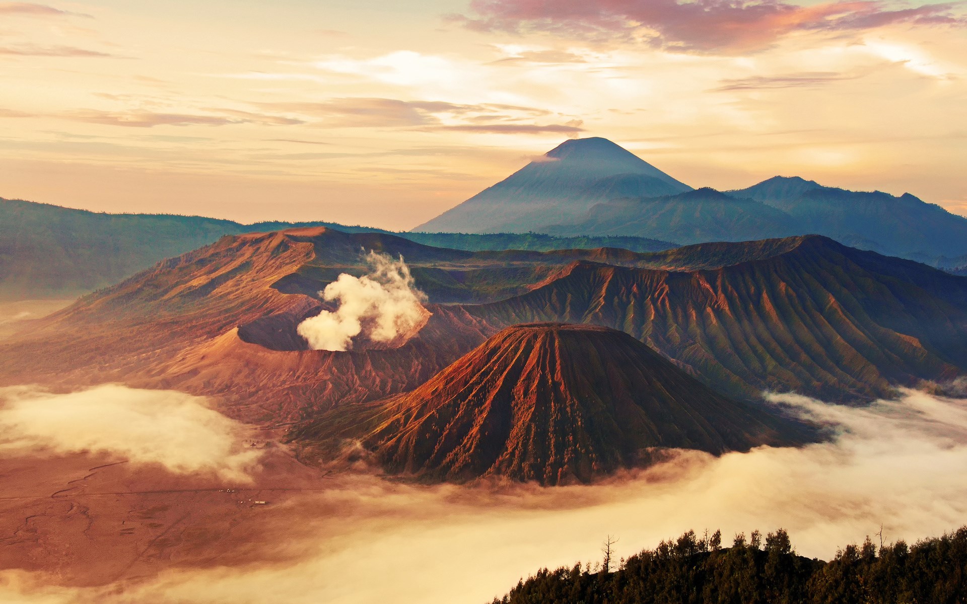 Volcanoes erupting with smoke at sunrise over clouds HD Wallpaper