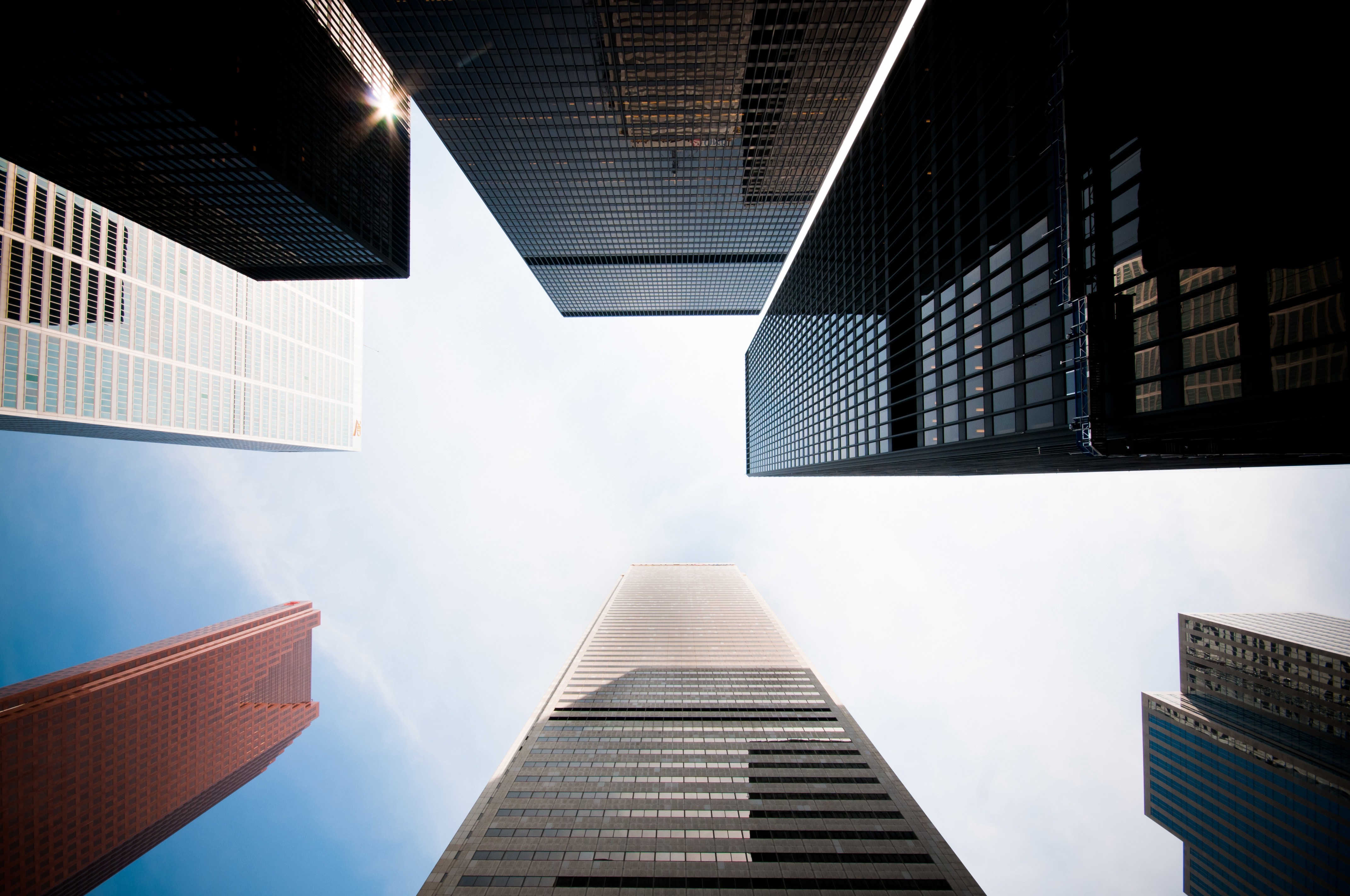 Skyscrapers viewed from below against a bright sky HD Wallpaper