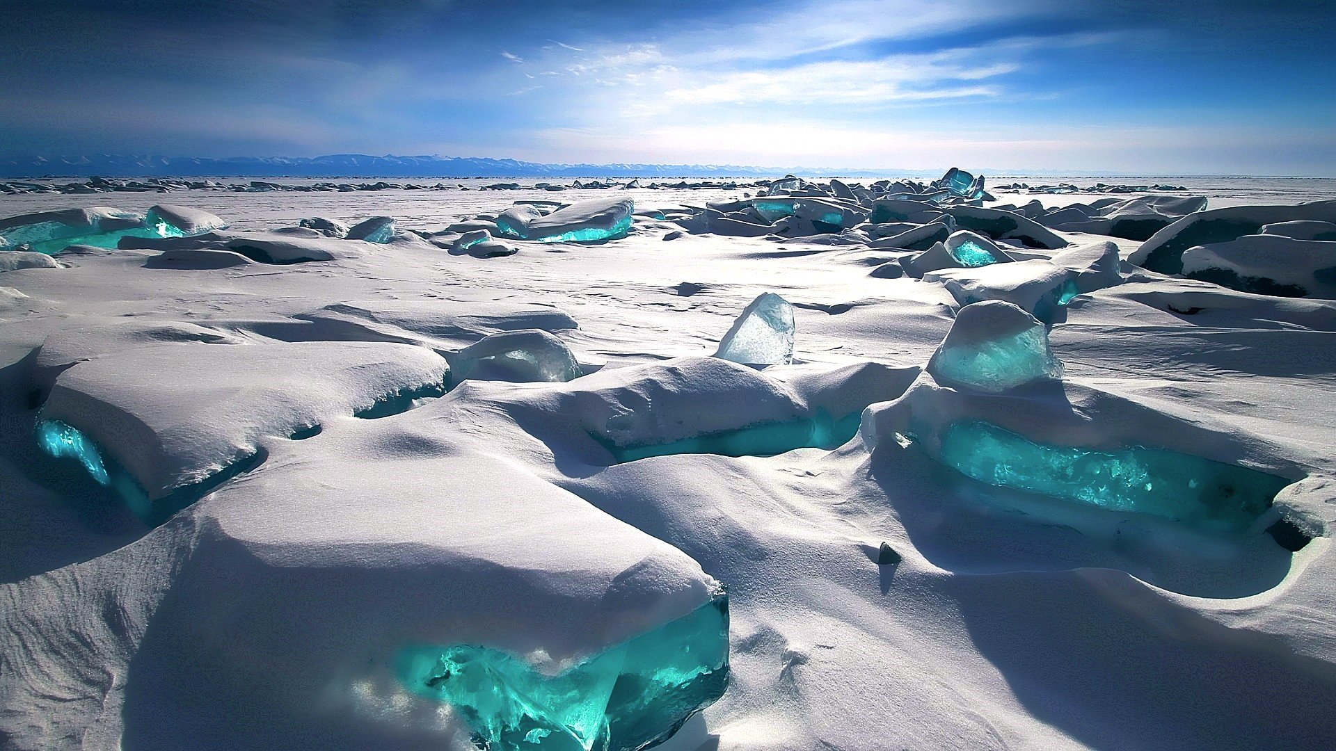 Blue ice formations on a snowy landscape under a blue sky HD Wallpaper