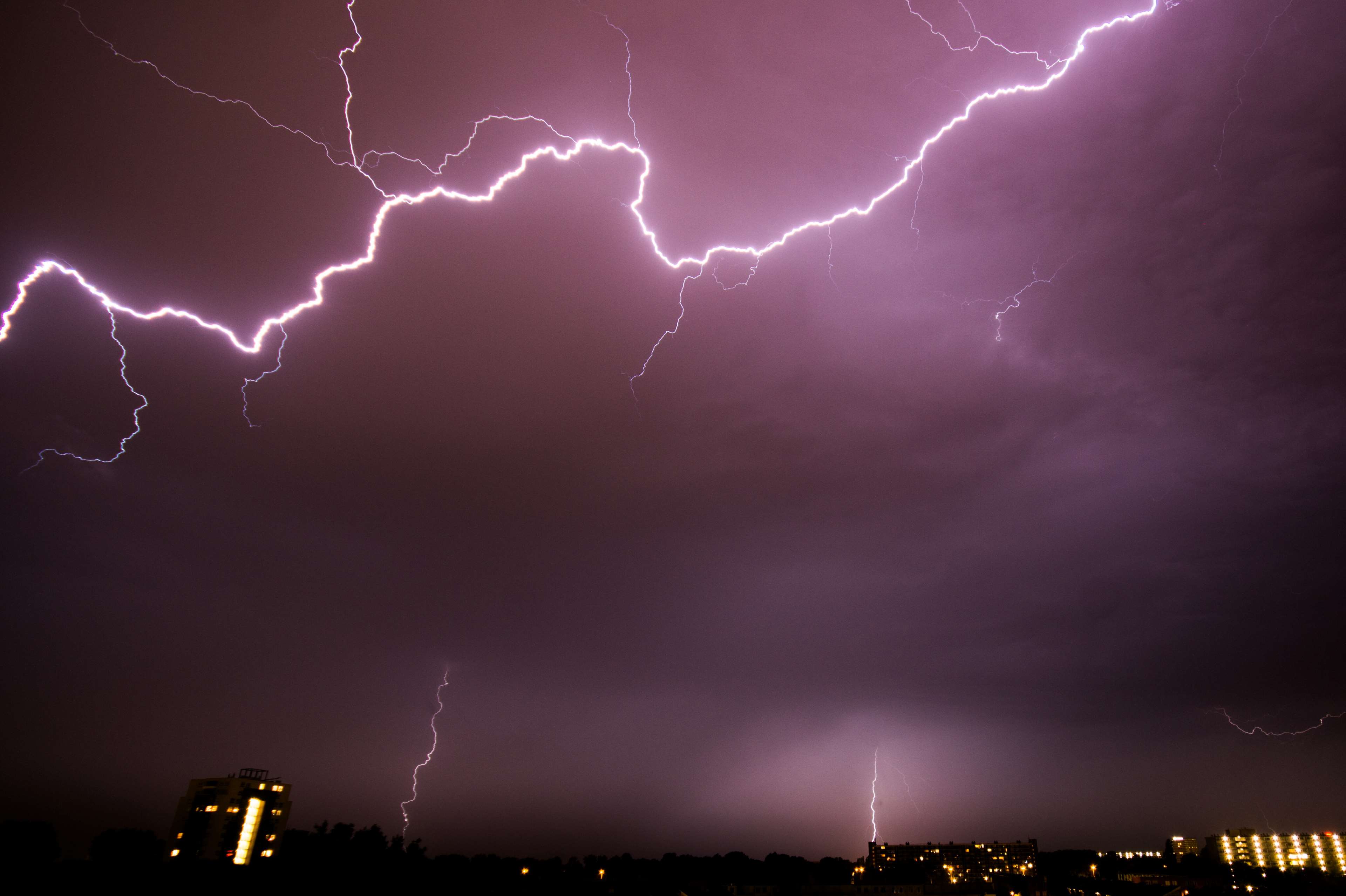 Lightning strikes over a city at night HD Wallpaper