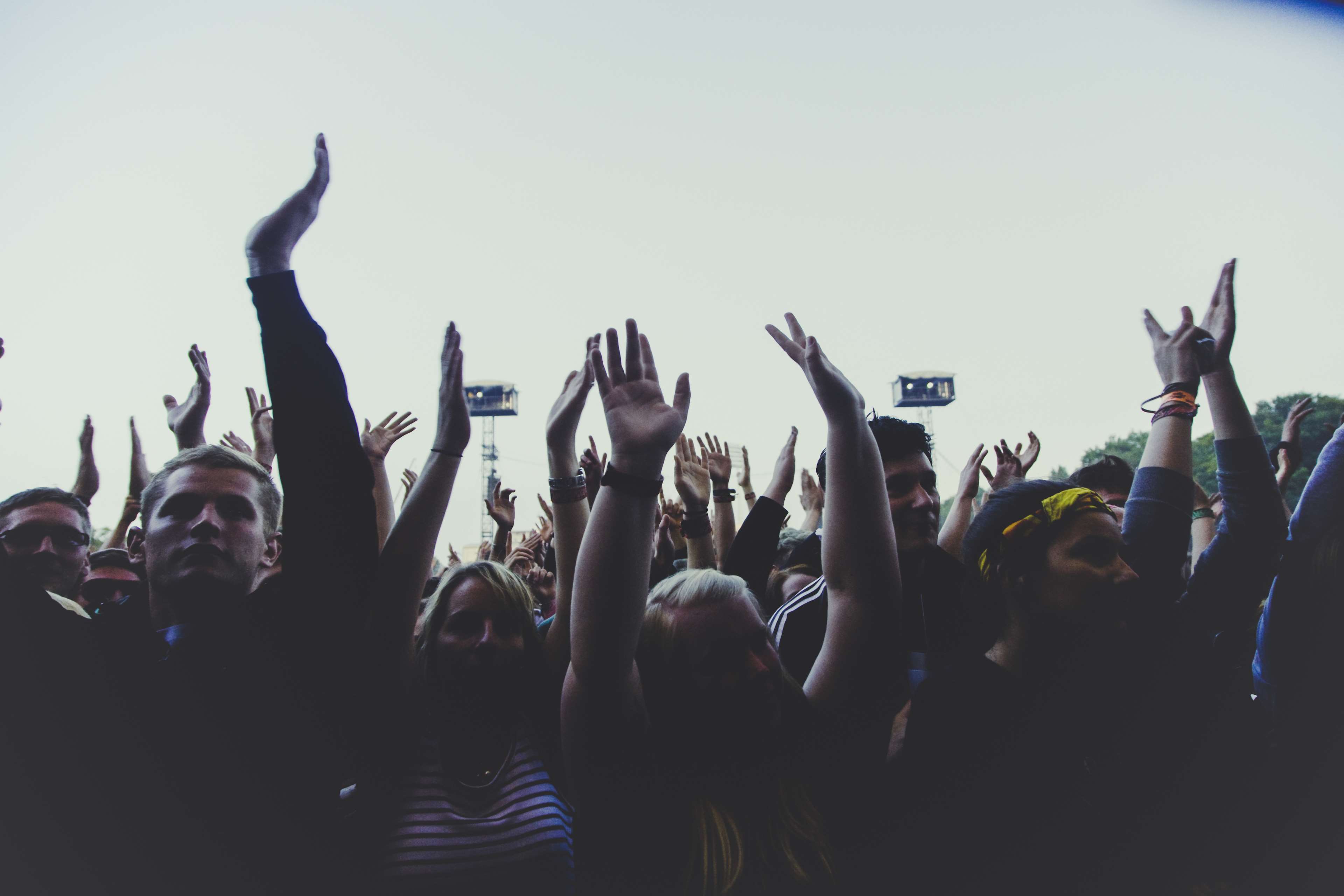 Crowd with hands raised at an outdoor music festival HD Wallpaper