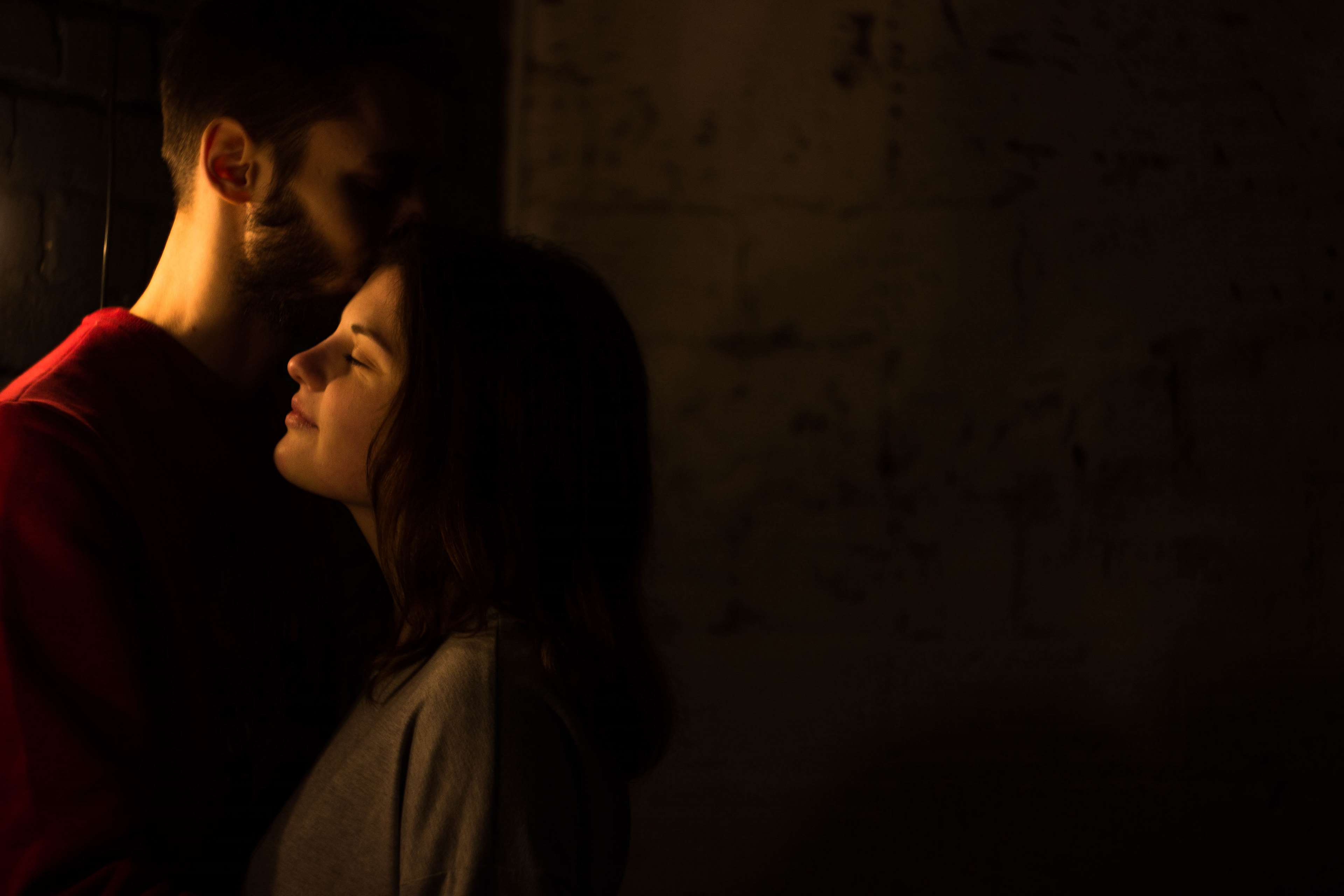 Couple embracing in dark room HD Wallpaper
