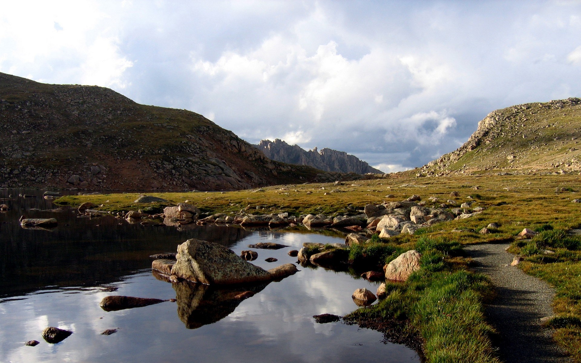 Rocky mountain lake with a hiking trail HD Wallpaper