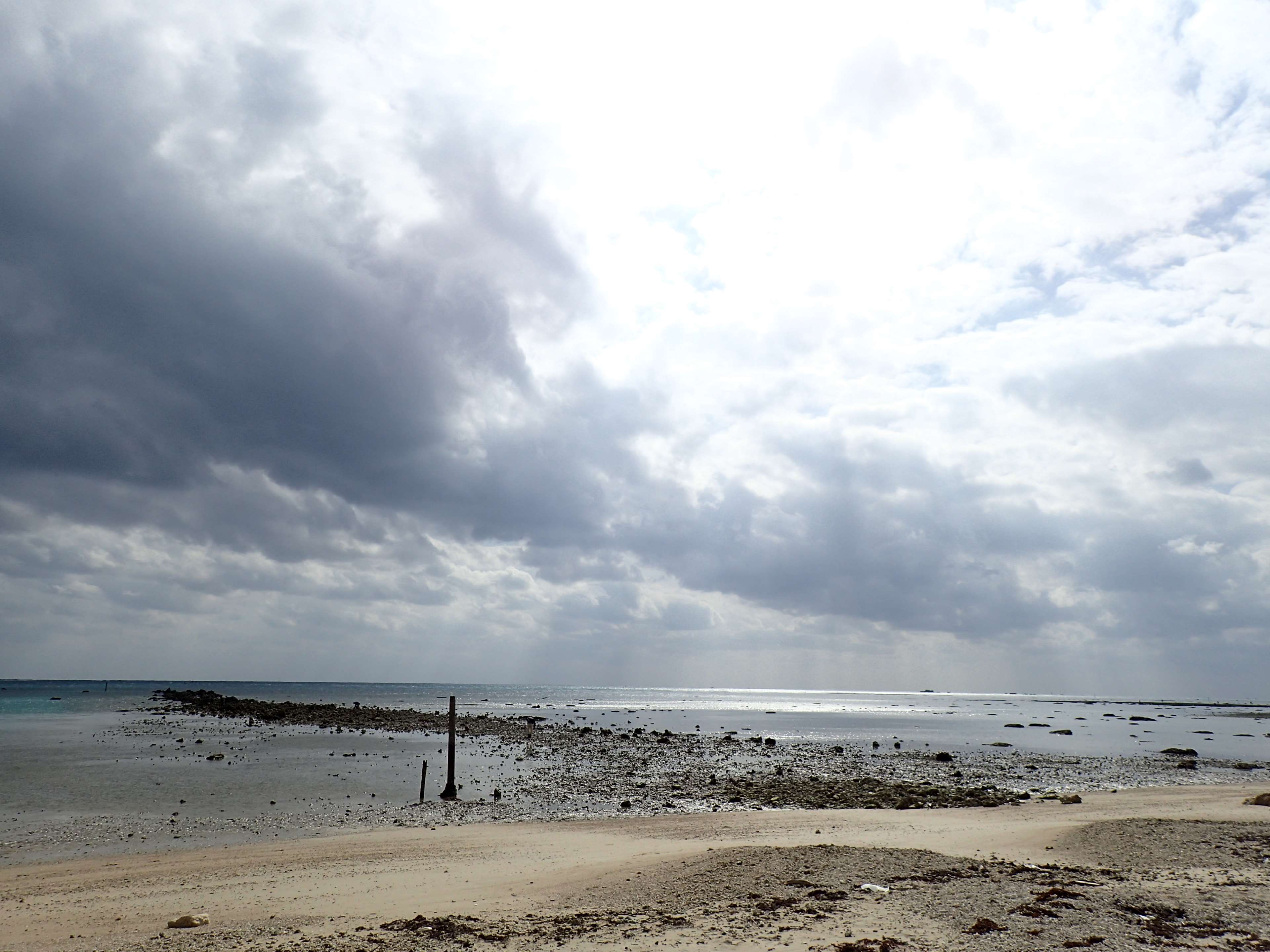 Cloudy sky over a rocky beach and the sea HD Wallpaper