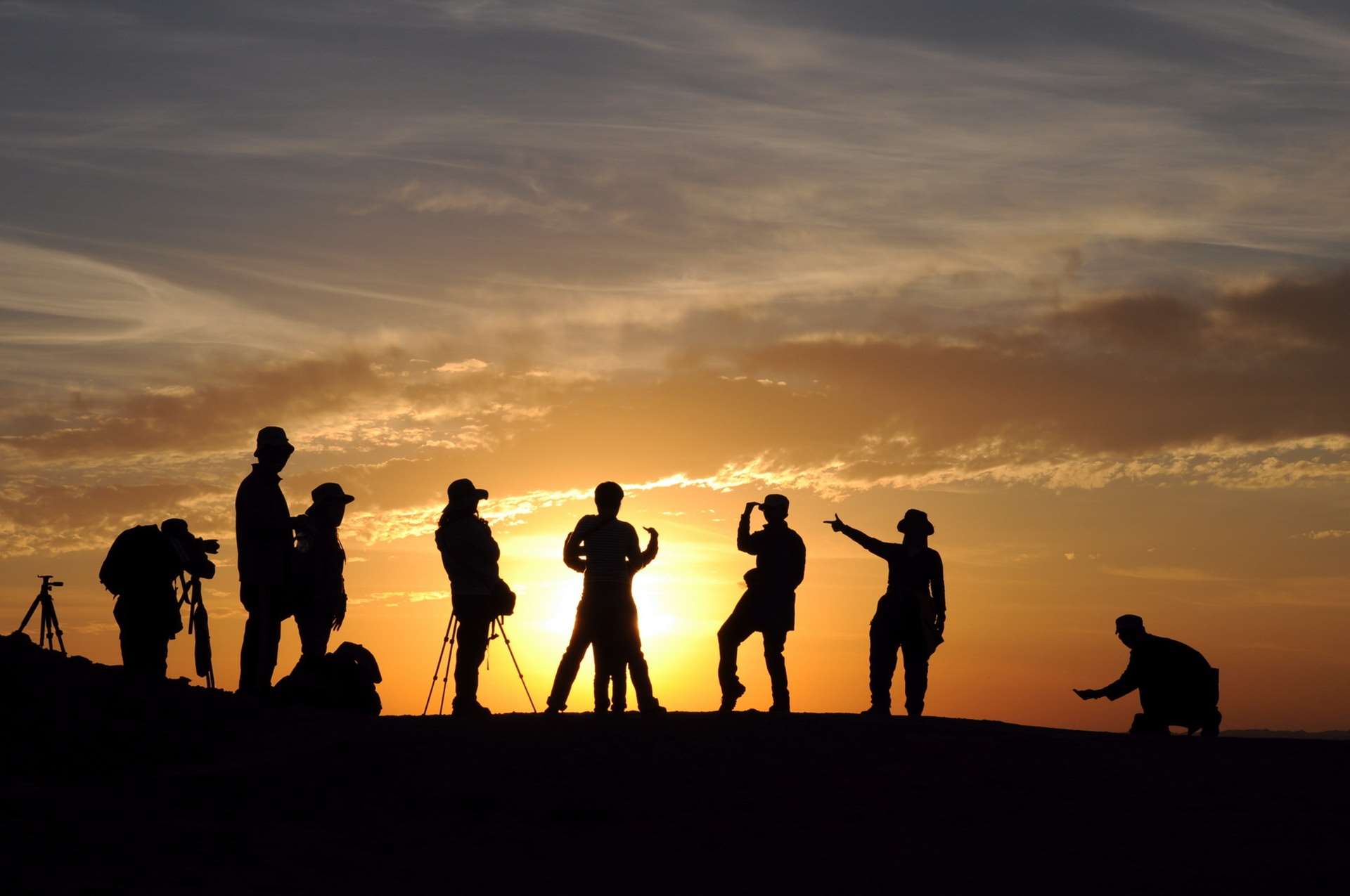 Silhouettes of people photographing a sunset HD Wallpaper