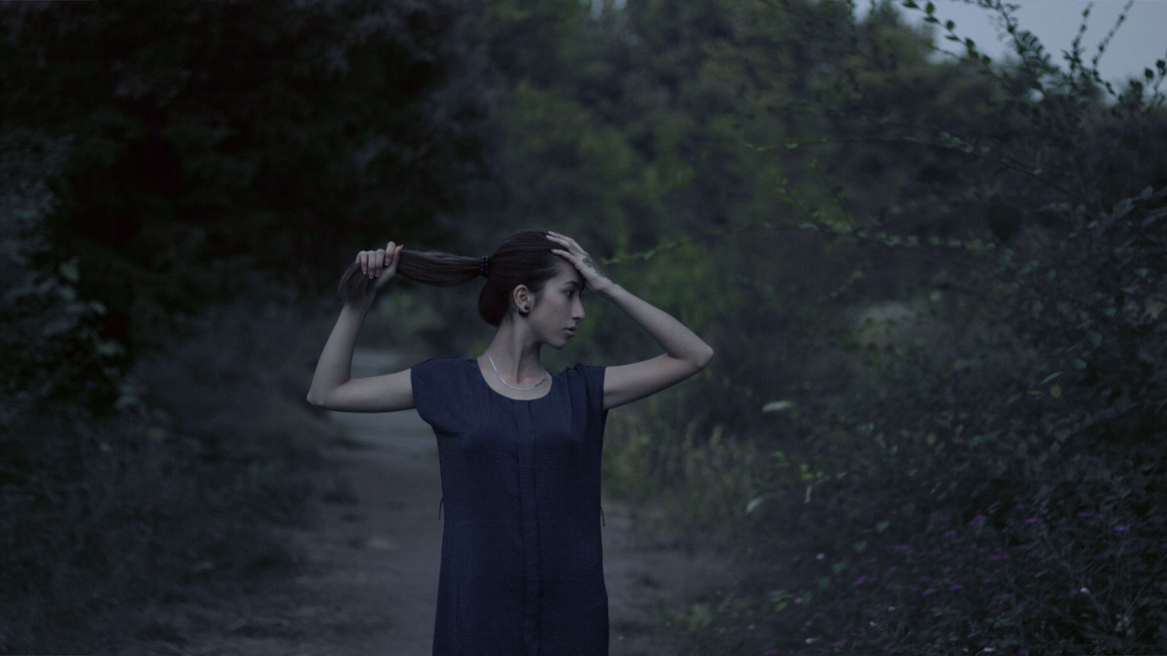 Woman in dark dress in a forest path HD Wallpaper