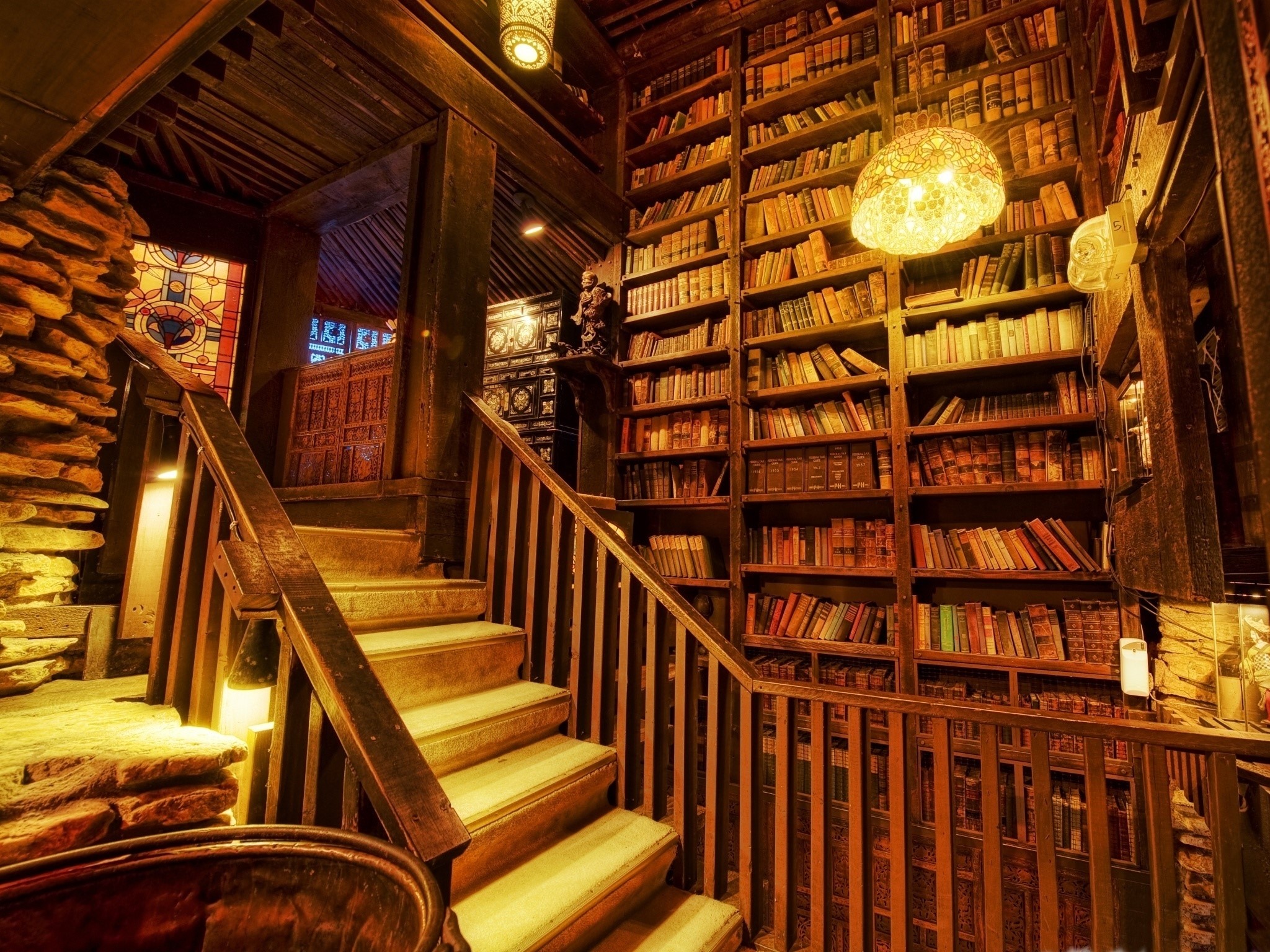 Interior of a library with wooden stairs and bookshelves HD Wallpaper