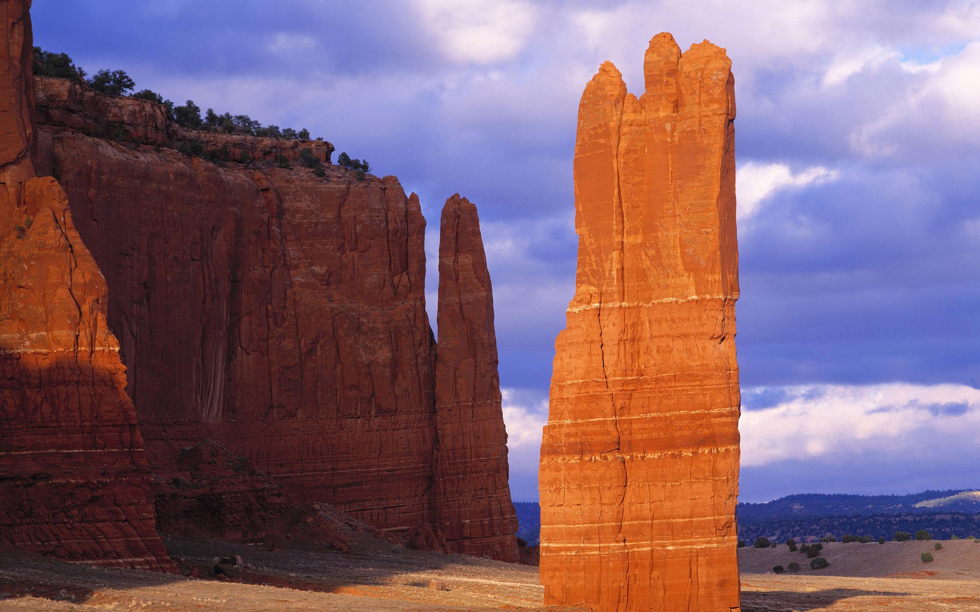 Red rock formations under a cloudy blue sky HD Wallpaper