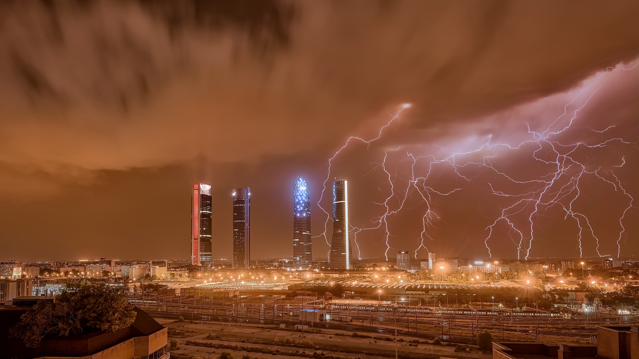 Lightning strikes over skyscrapers in Madrid at night HD Wallpaper