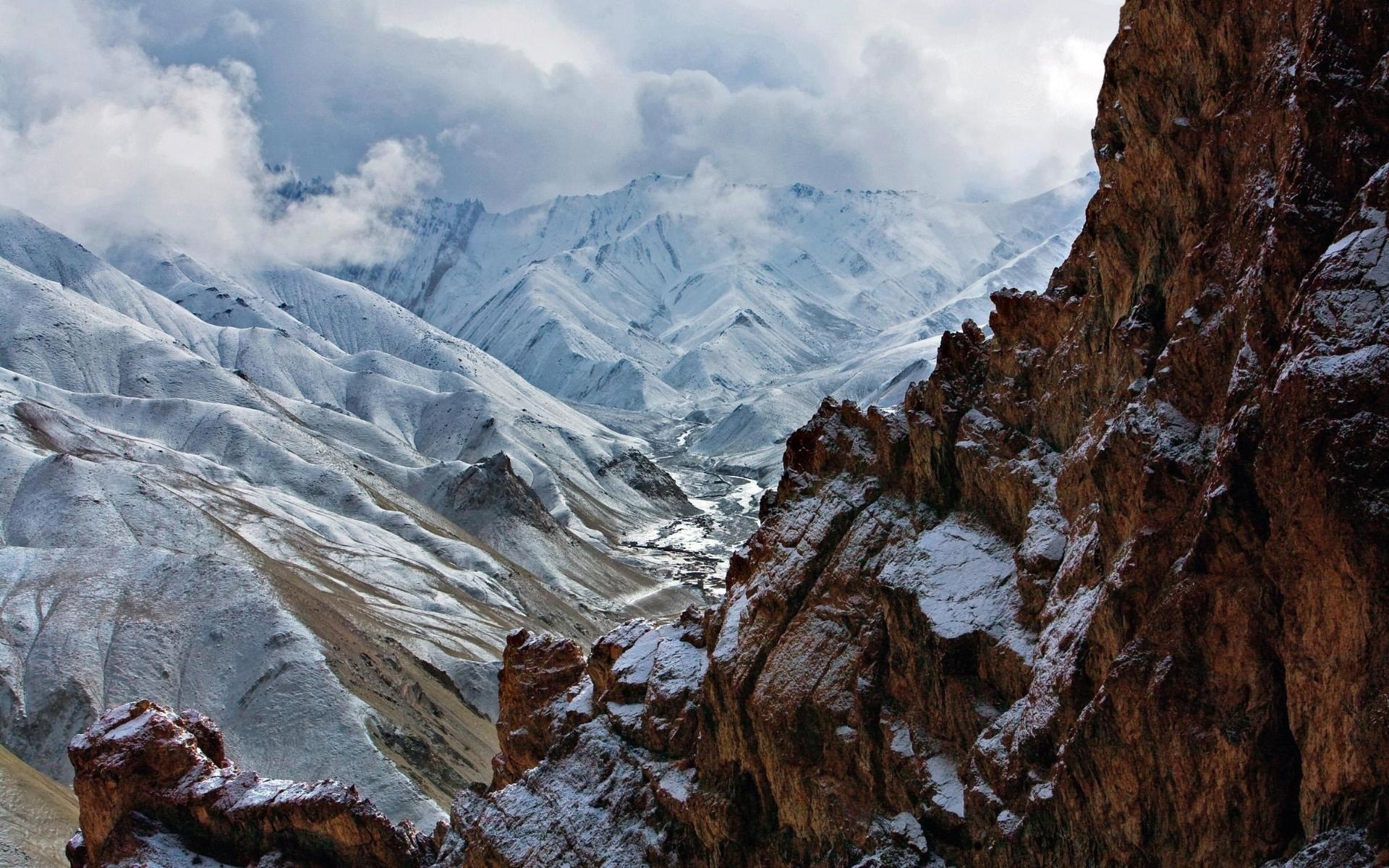 Snow-covered mountains and rocky foreground HD Wallpaper