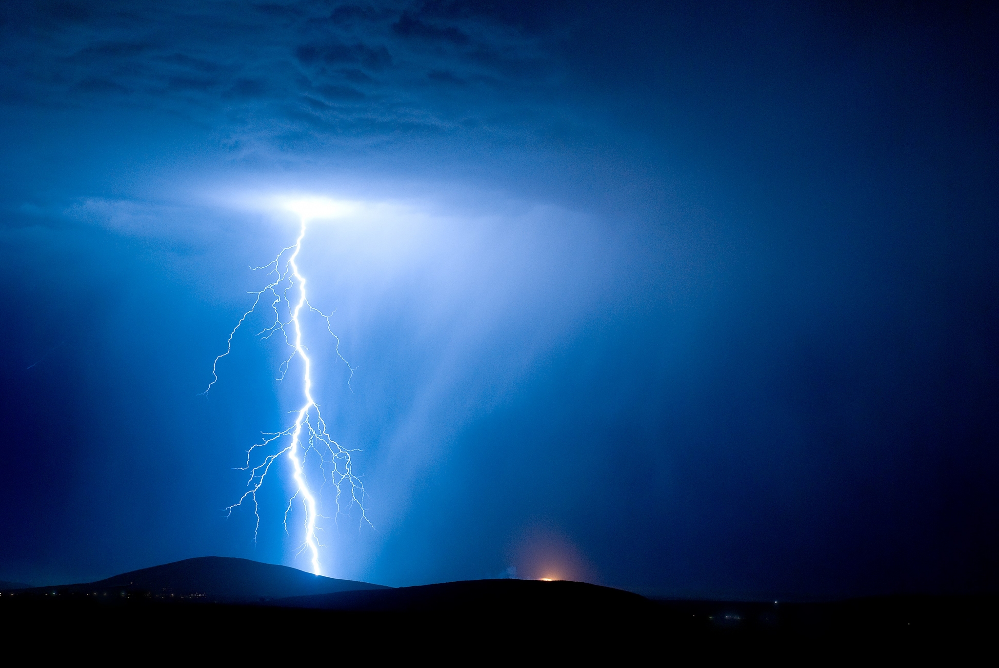 Lightning strike over dark hills at night HD Wallpaper