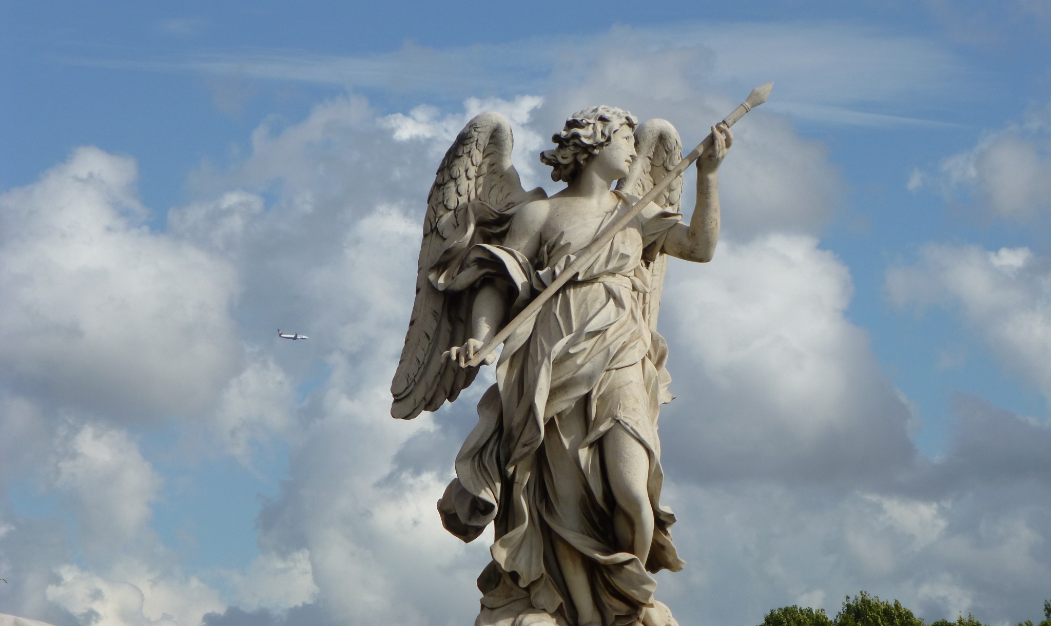 Angel statue holding a spear with an airplane in the sky HD Wallpaper