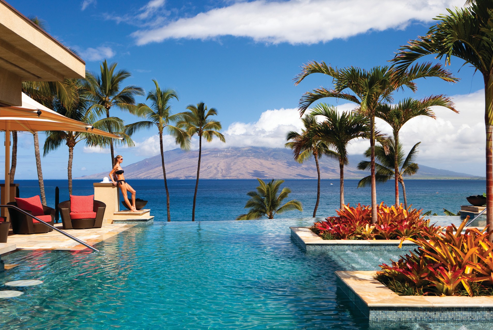 Woman in bikini by infinity pool overlooking ocean in Hawaii HD Wallpaper