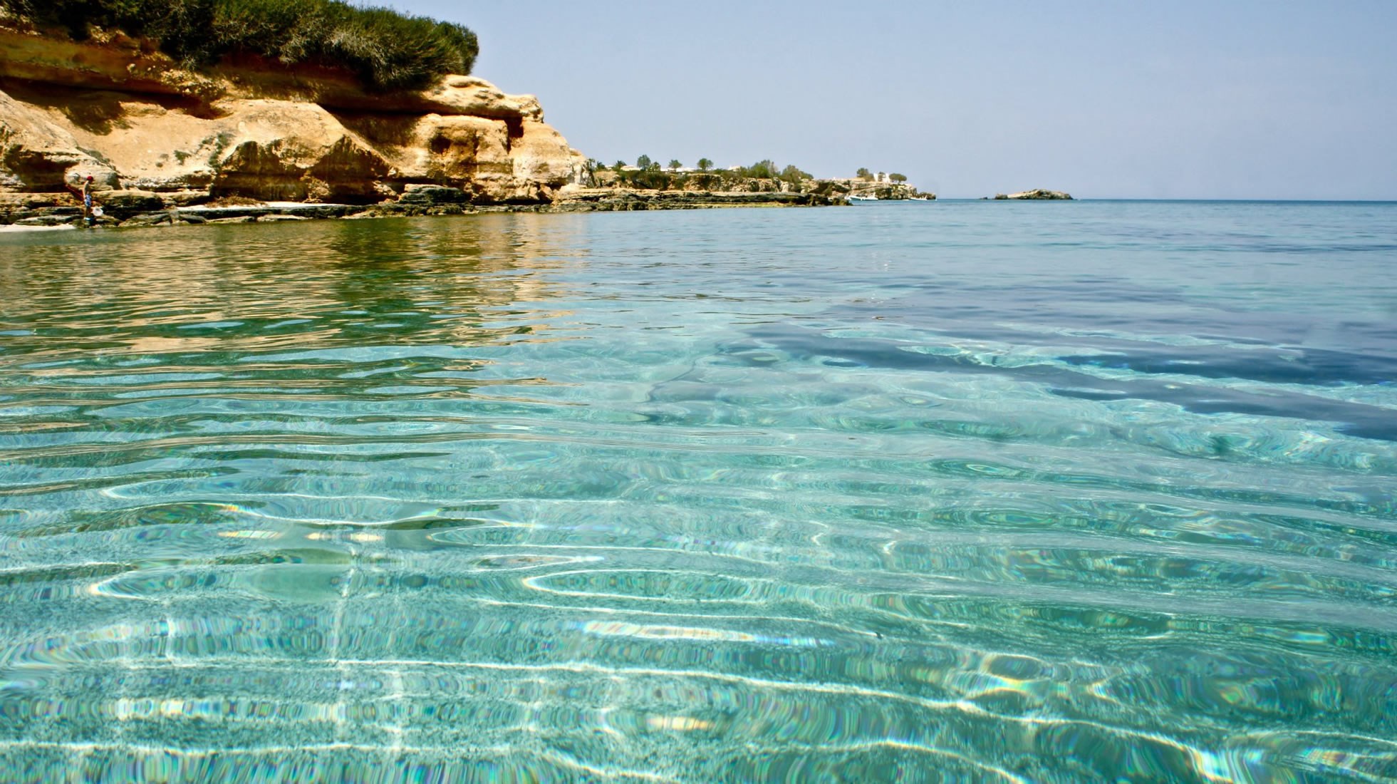 Crystal clear water by a rocky coastline HD Wallpaper
