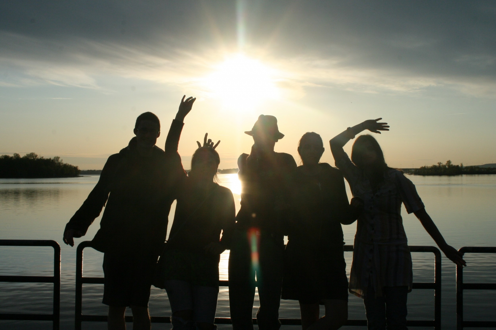 Group of friends silhouetted against the sun HD Wallpaper