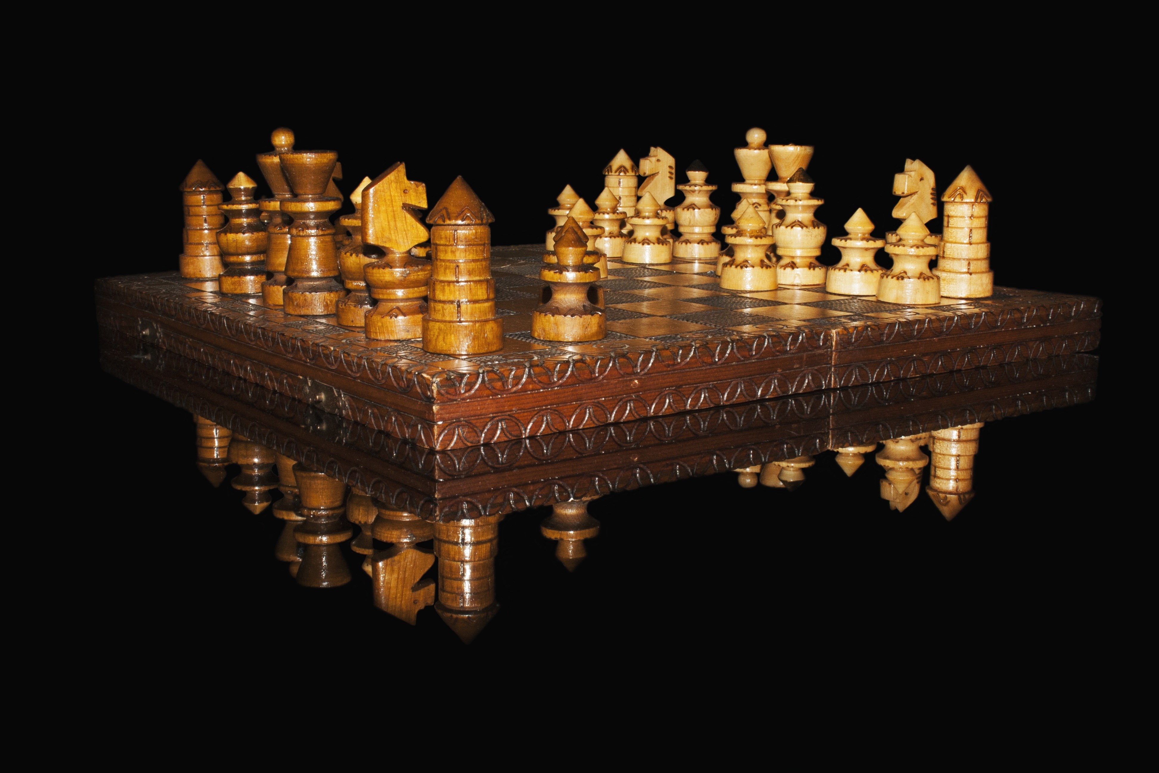 Wooden chess set on a reflective surface HD Wallpaper