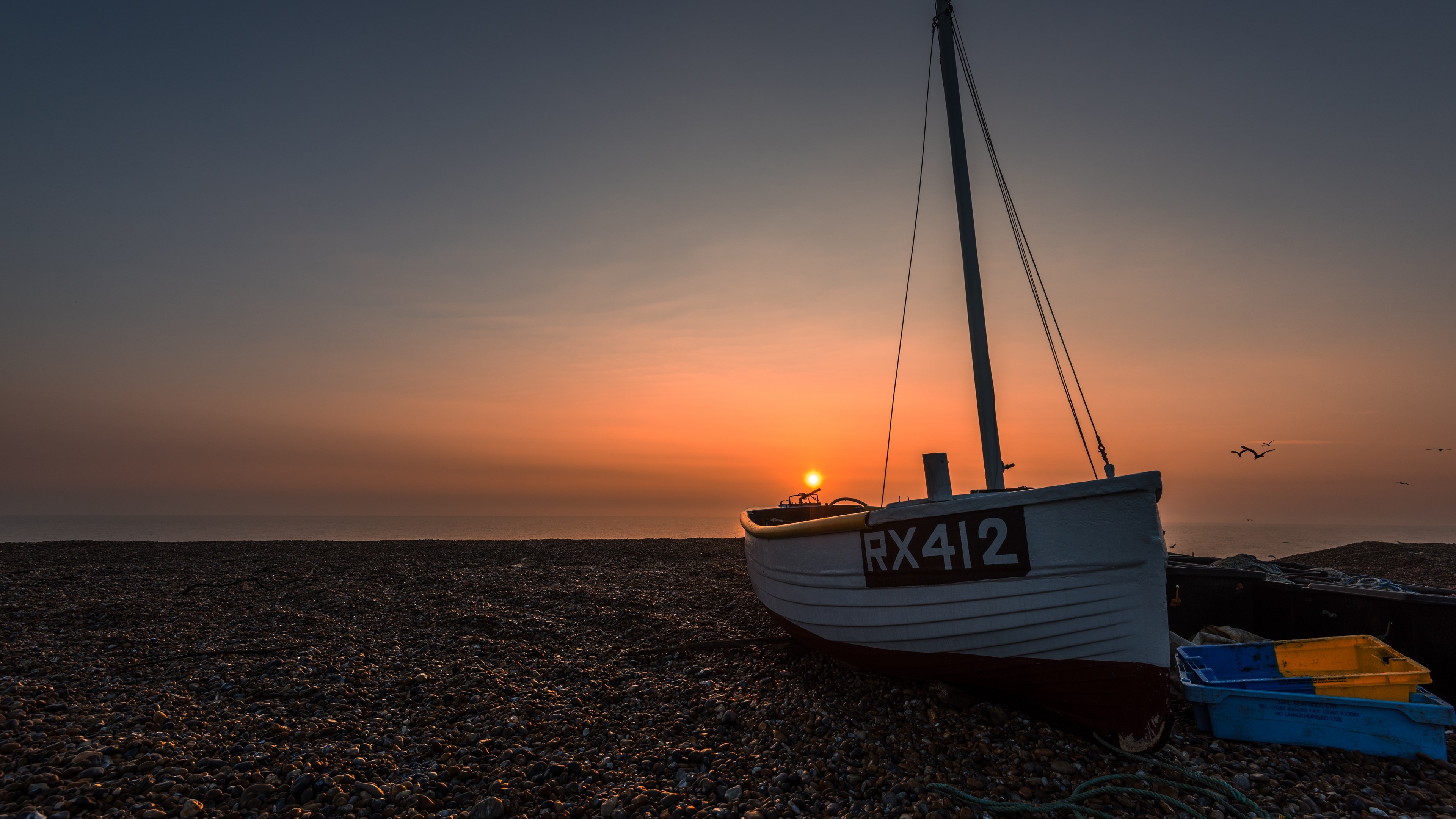 Fishing boat on a beach at sunset HD Wallpaper