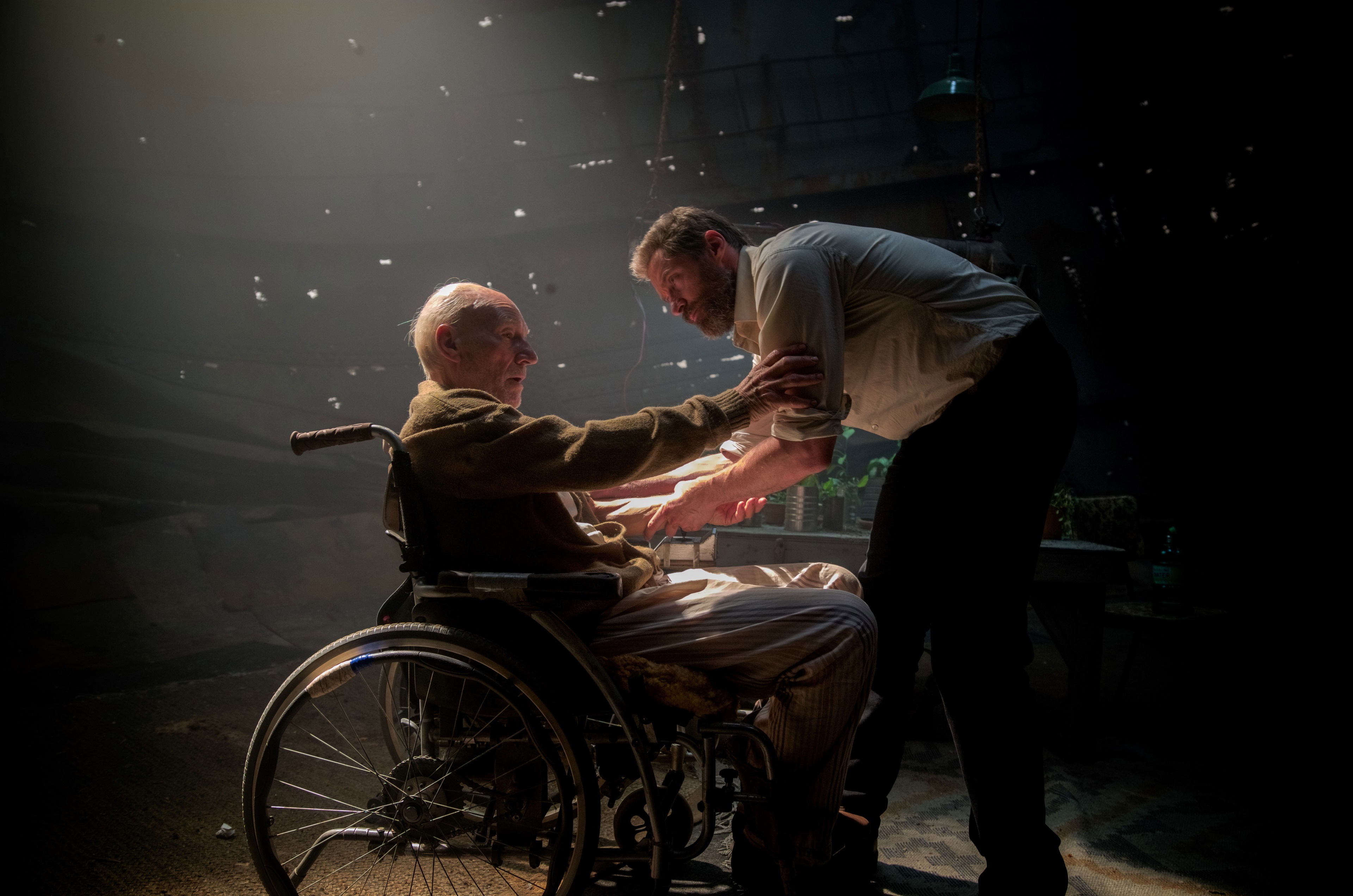 Logan in a wheelchair with a man helping him HD Wallpaper