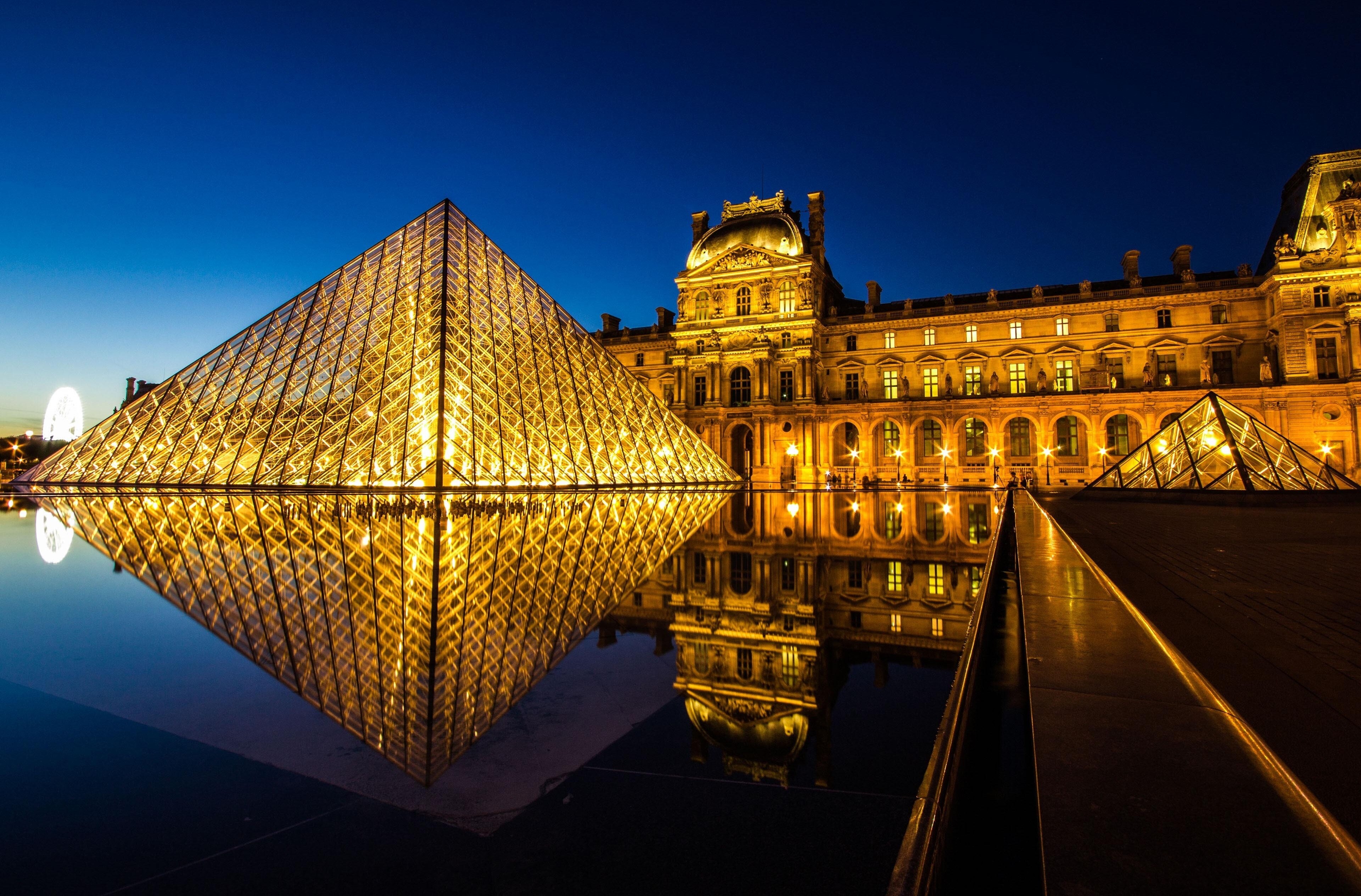 Louvre Museum at night with pyramid and reflection HD Wallpaper
